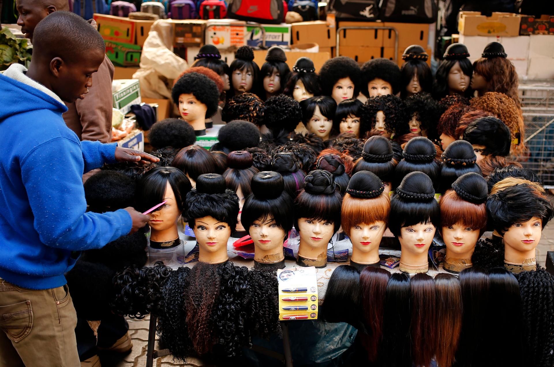 A man prepares wigs as he waits for customers in downtown Johannesburg.