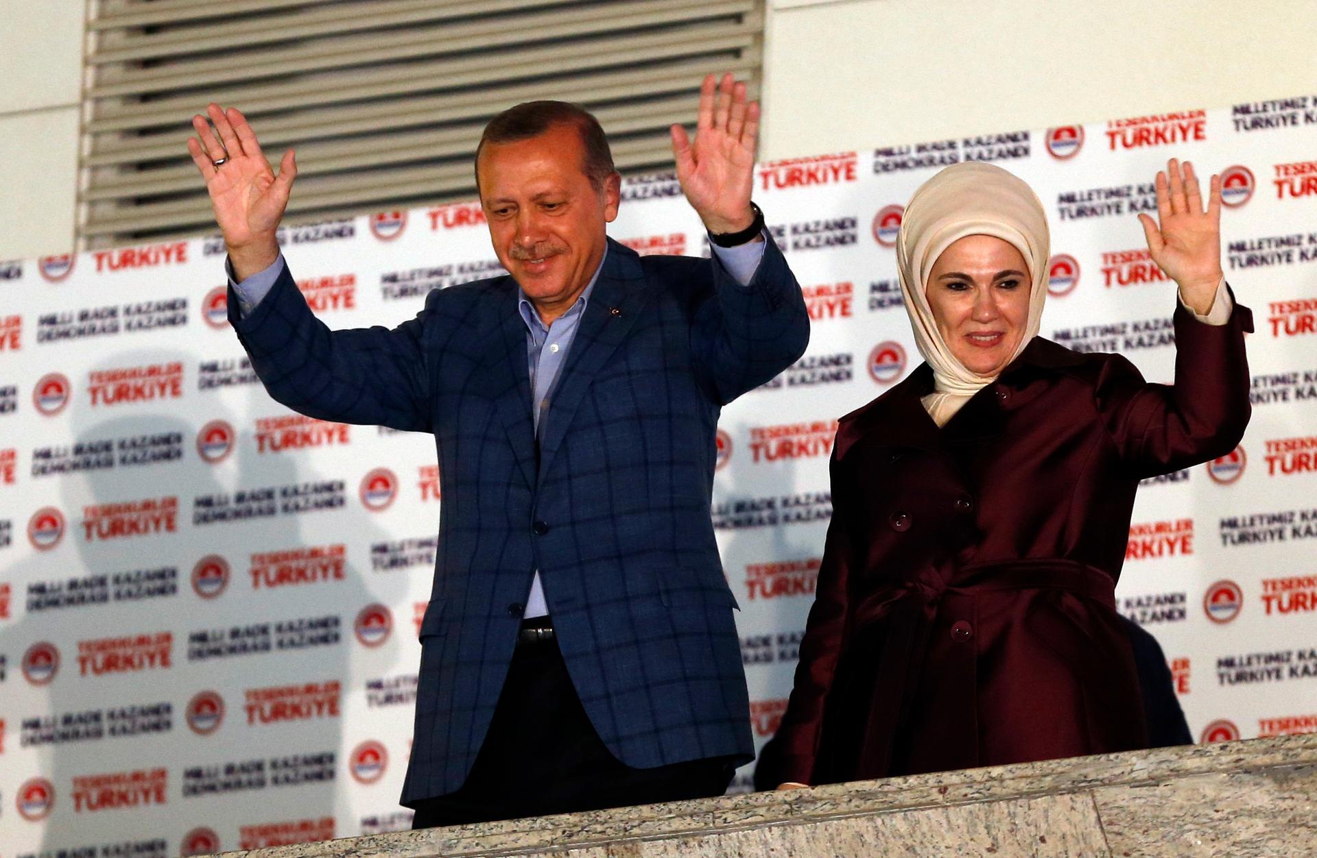 Recep Tayyip Erdogan, Turkey's Prime Minister, and his wife, Ermine, wave hands to supporters as they celebrate his election victory in front of the Justice and Development party headquarters in Ankara on August 10, 2014.