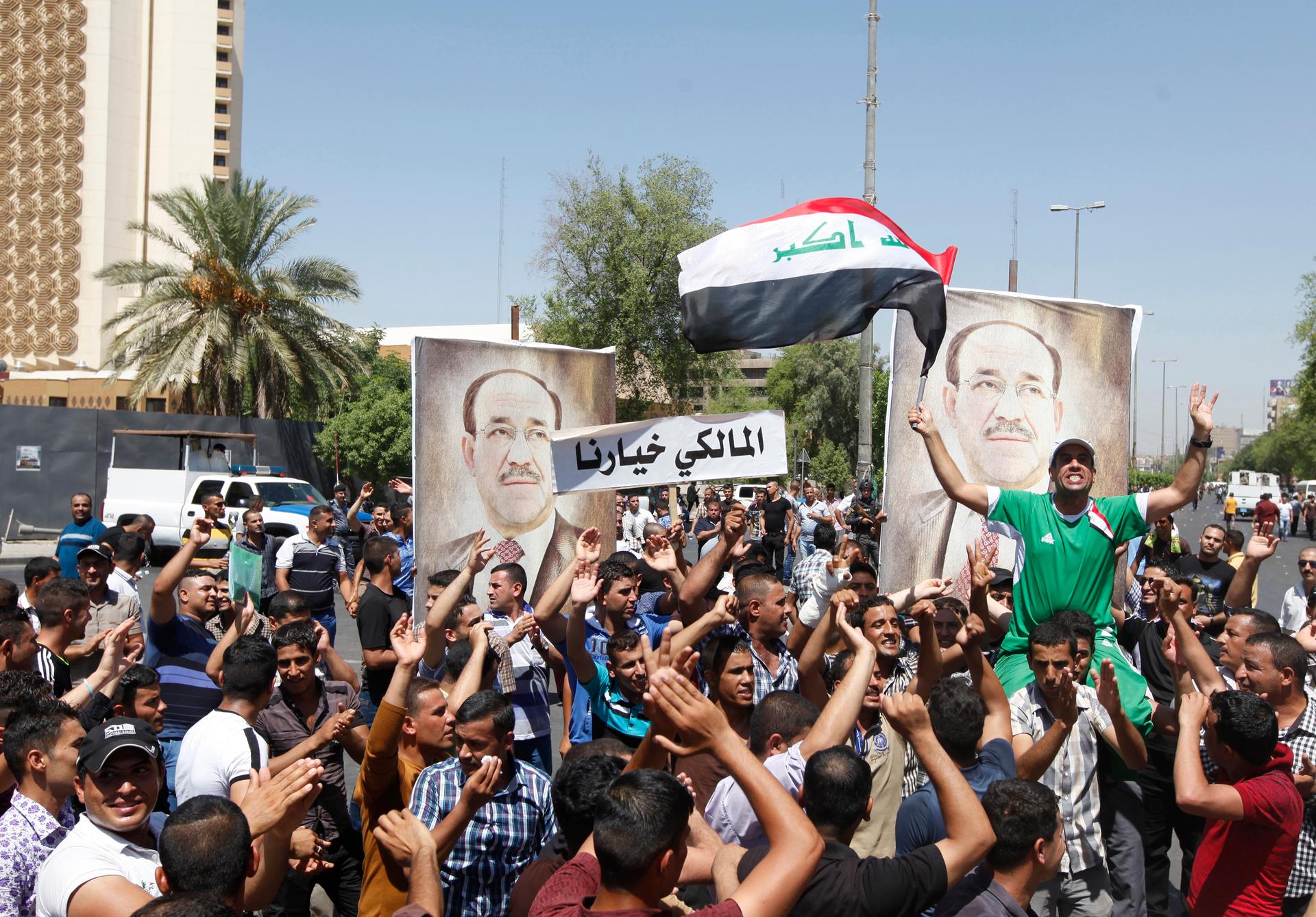 People with portraits of Iraqi Prime Minister Nouri al-Maliki rally in support of him in Baghdad on August 11, 2014. 