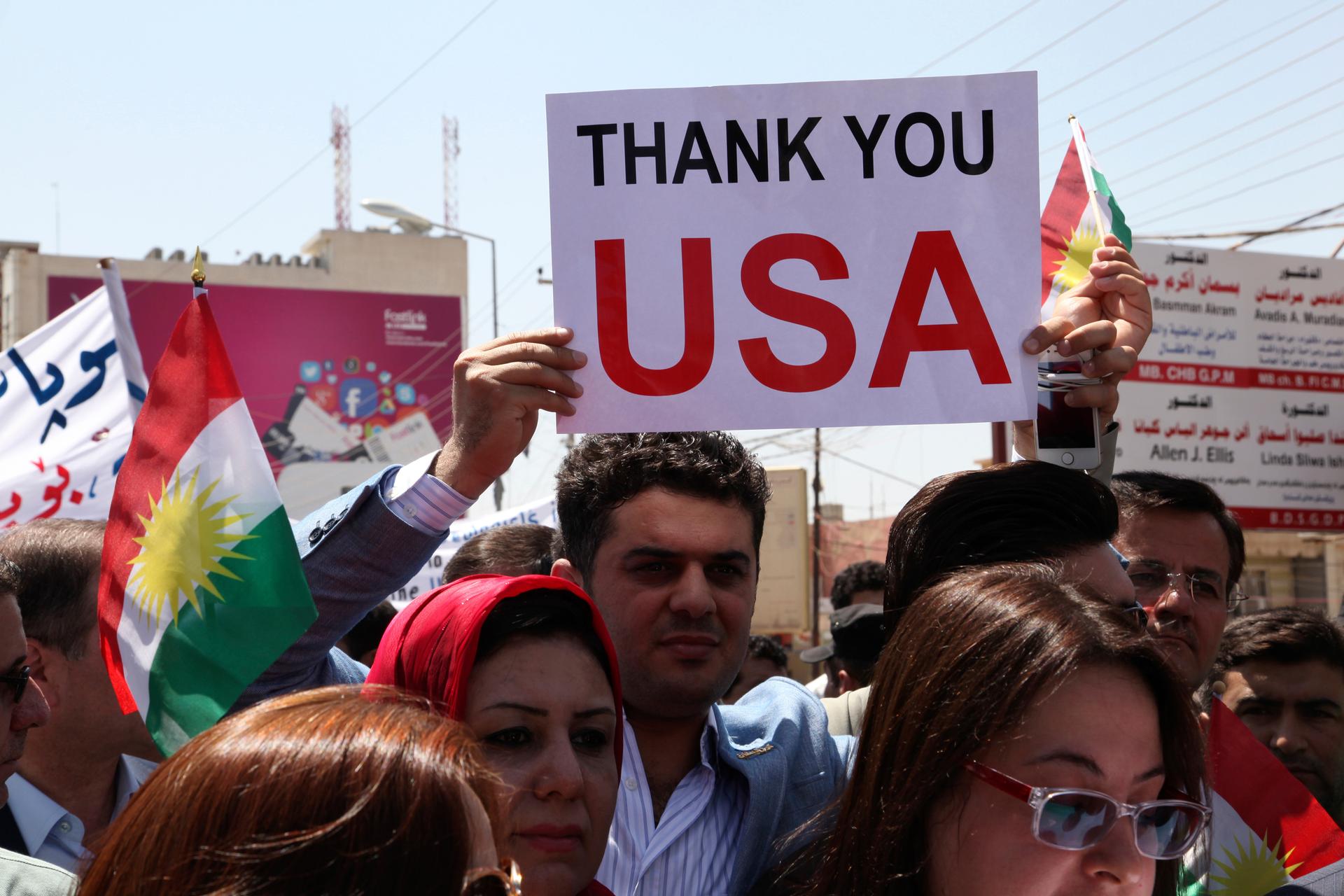 A Kurdish resident holds a signs during a demonstration in support of peshmerga troops in front of the US consulate in Erbil, Iraq.