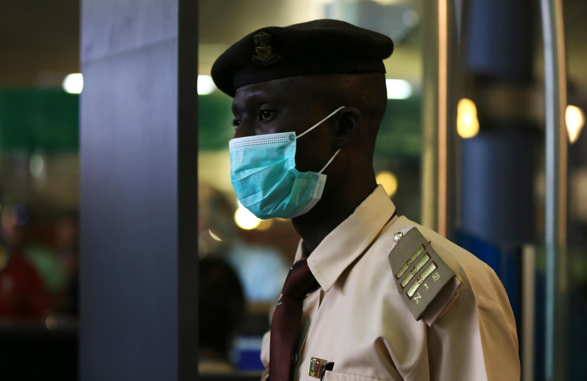 An immigration officer wears a face mask at the Nnamdi Azikiwe International Airport in Abuja August 11, 2014.