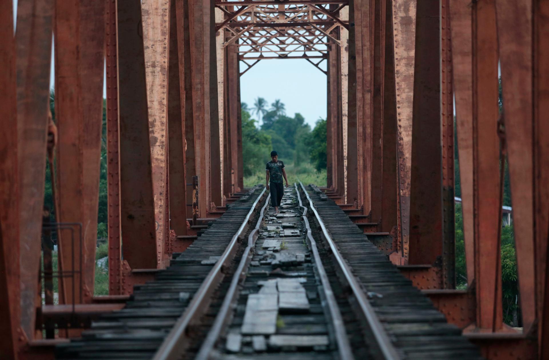 A Central American migrant walks on the train tracks in Mexico en route to the US border.