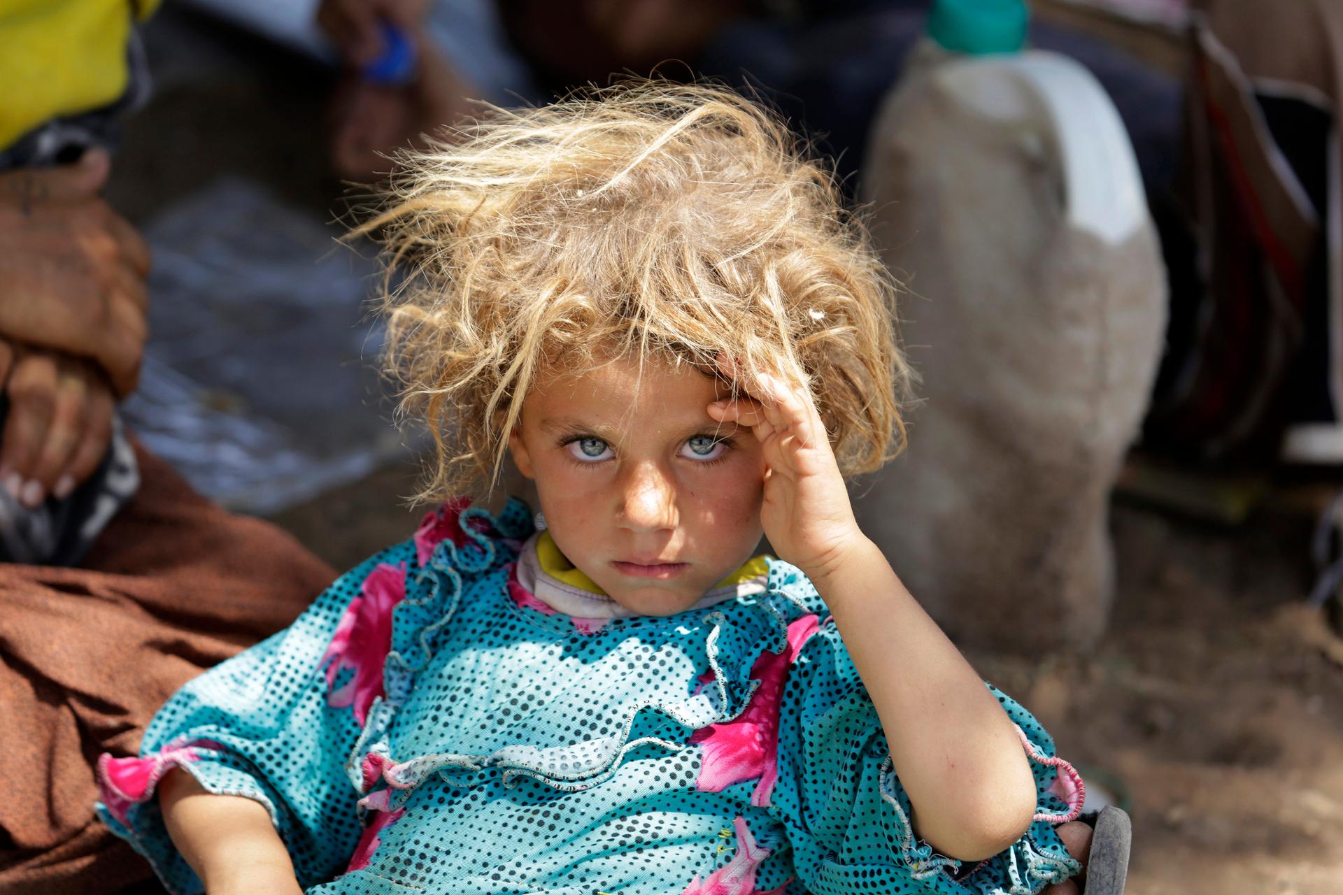A girl from the minority Yazidi sect, fleeing the violence in the Iraqi town of Sinjar, rests at the Iraqi-Syrian border crossing in Fishkhabour, Dohuk province August 13, 2014.