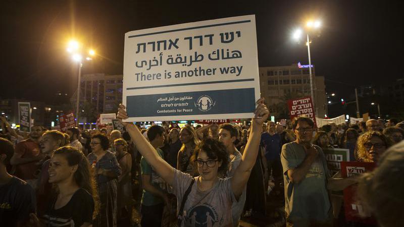 A woman holds up a placard during a peace rally in Tel Aviv's Rabin Square.