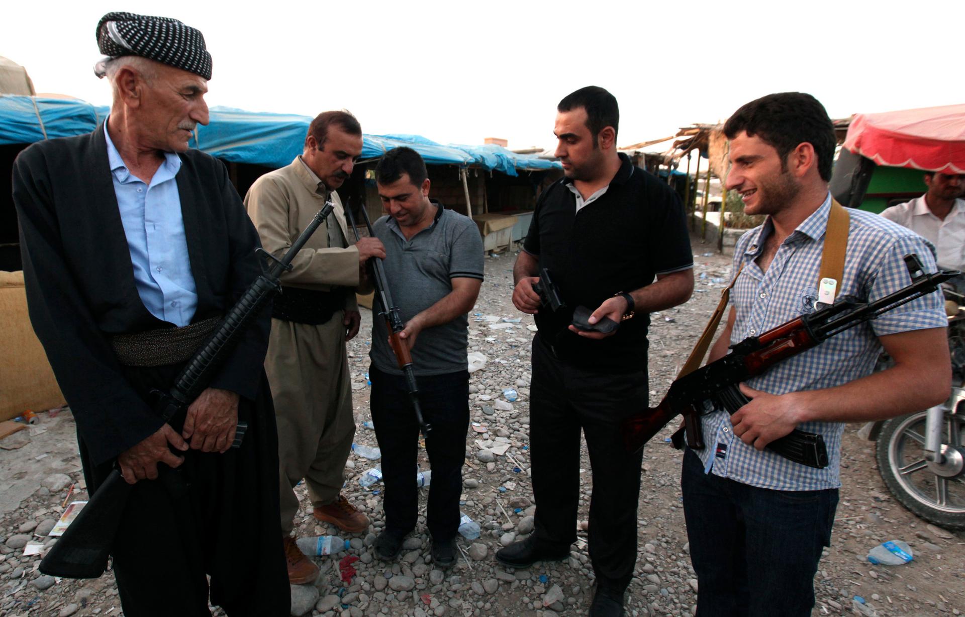Kurdish men display weapons for sale at an arms market in Irbil, capital of the autonomous Kurdish region of northern Iraq.