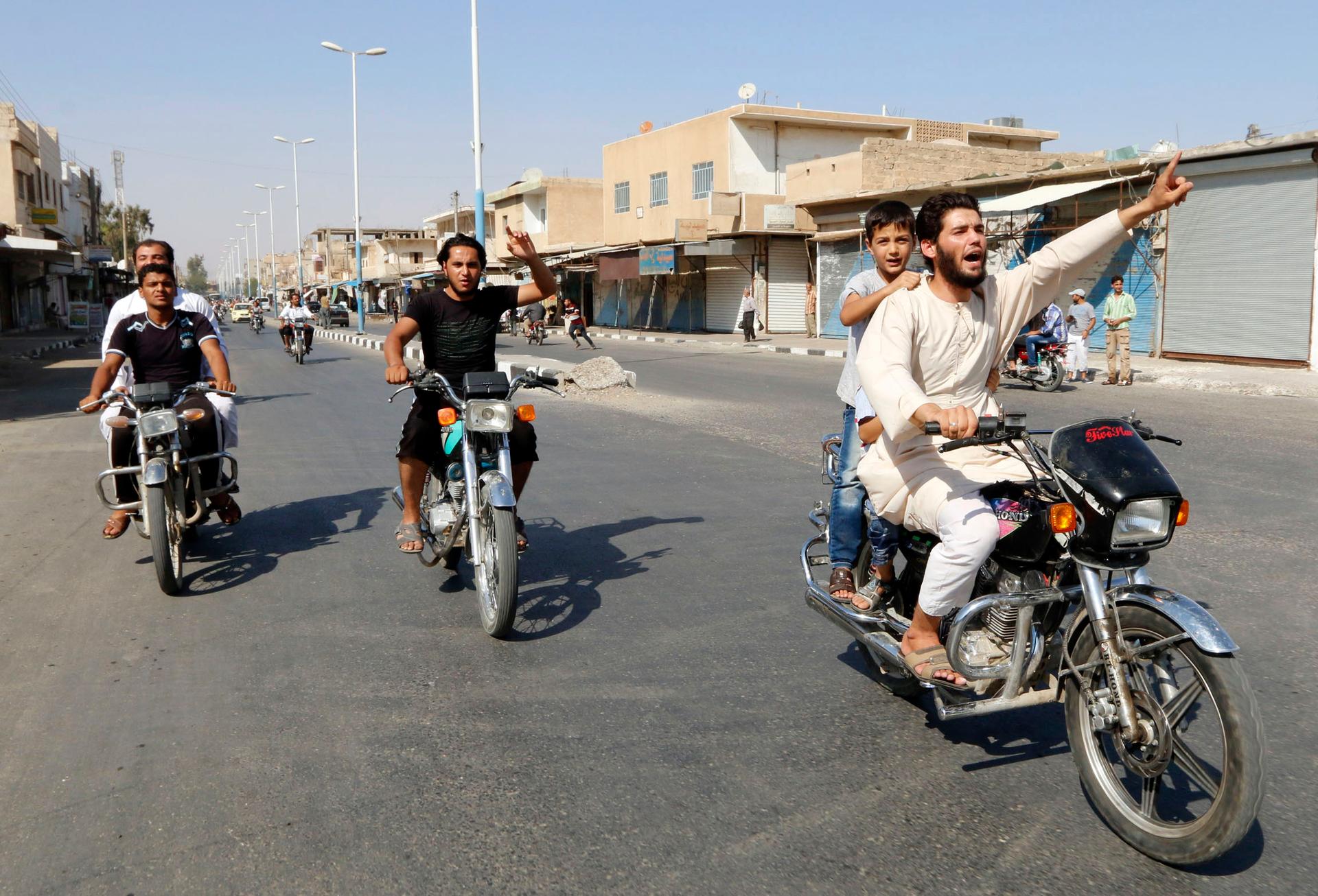 People in the Syrian city of Tabqa toured the streets in celebration after Islamic State militants took over a government air base nearby on August 24, 2014.
