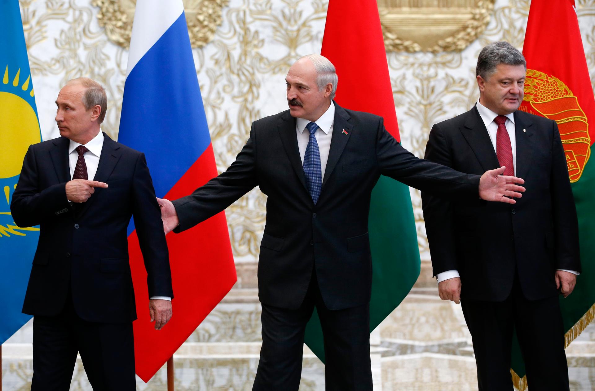 Russia's President Vladimir Putin, Belarus' President Alexander Lukashenko and Ukraine's President Petro Poroshenko react while posing for a group photo during peace talks that started in Minsk on August 26, 2014.