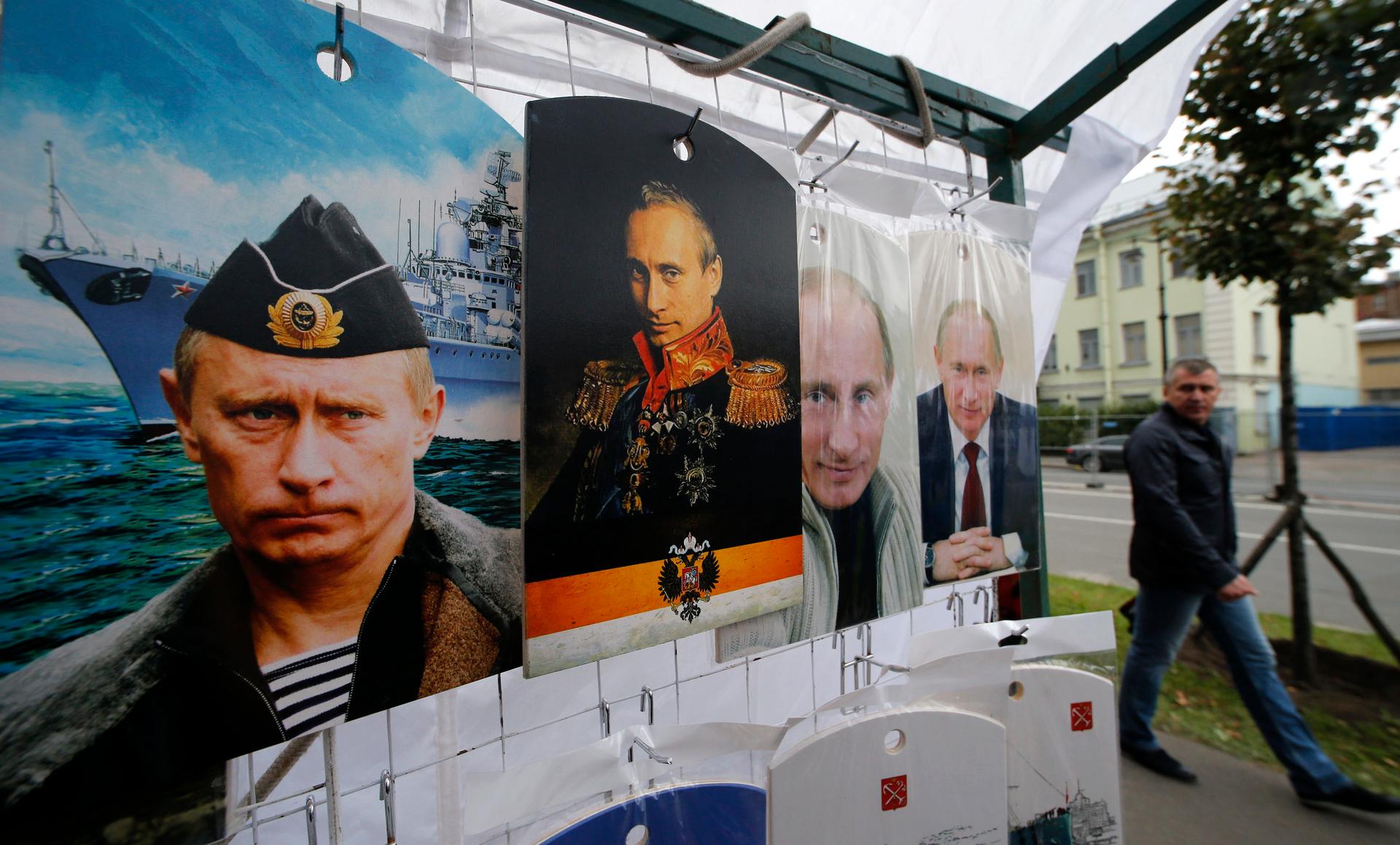 A man walks past cutting boards that have been painted with images of Russia's President Vladimir Putin at a street store in the center of St. Petersburg on August 31, 2014.