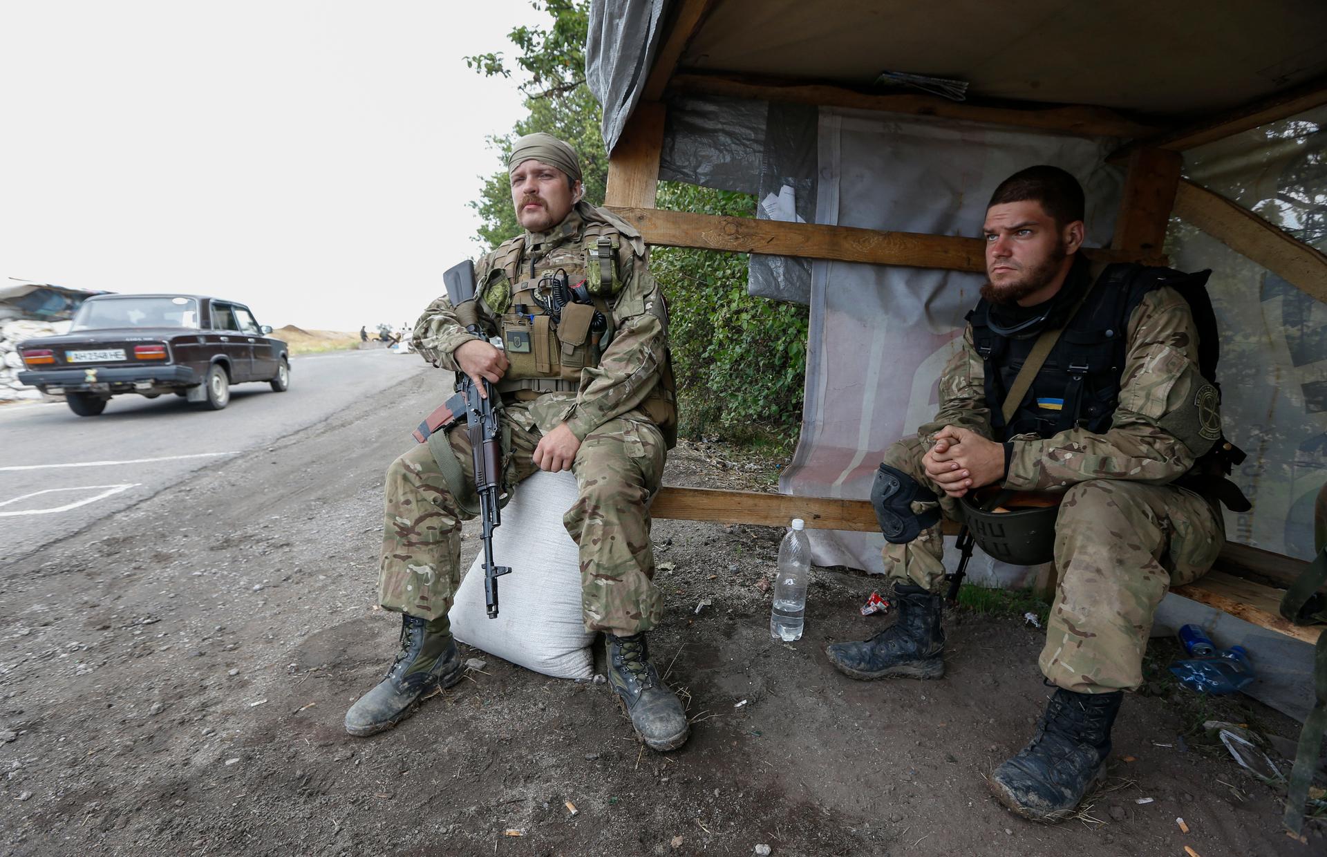 Soldiers from the Ukrainian self-defence battalion "Azov" sit at a checkpoint in the southern coastal town of Mariupol on September 8, 2014. 