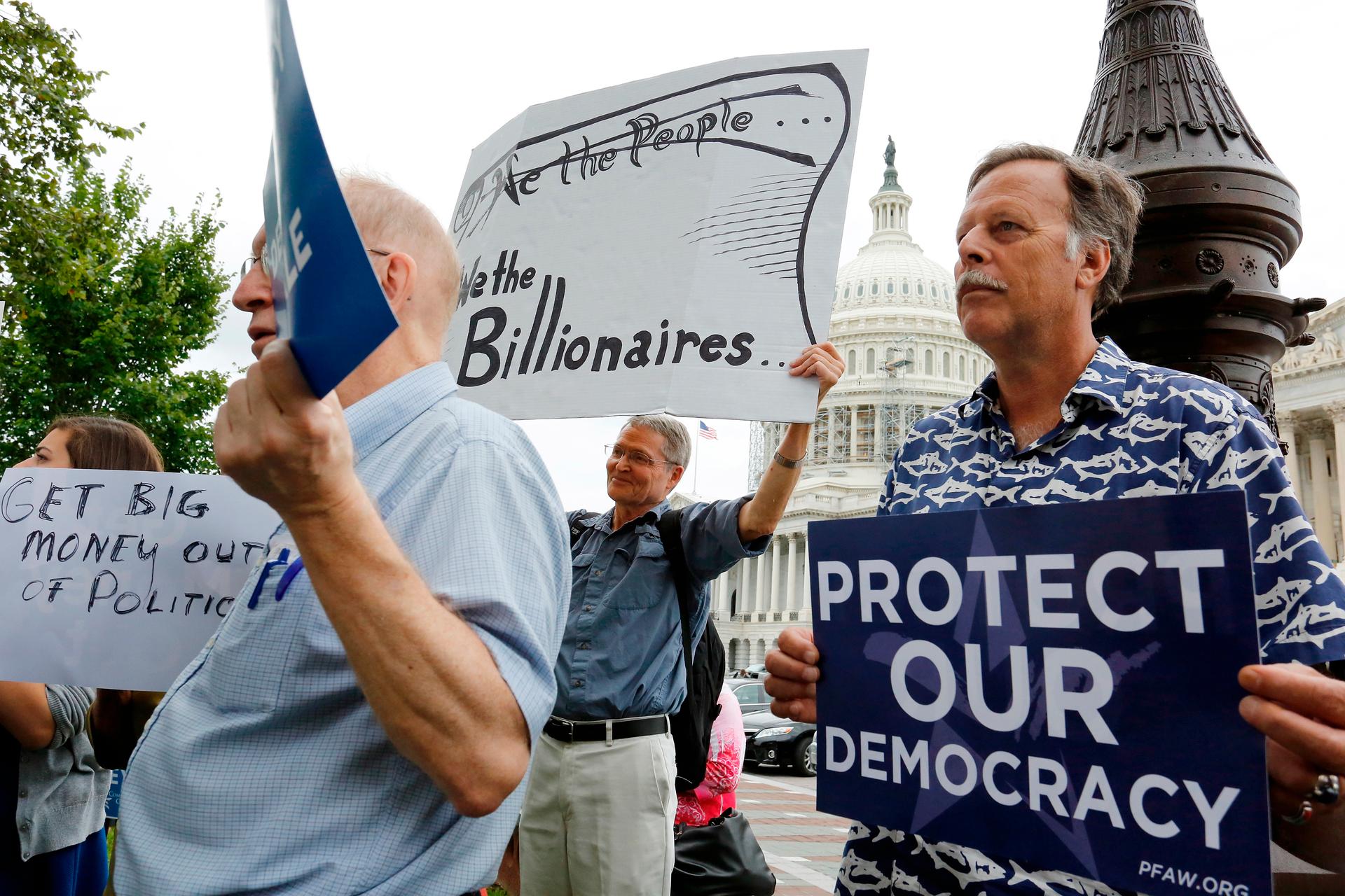 Supporters look on at a news conference on Capitol Hill led by Democratic senators and congressmen in support of a proposed constitutional amendment for campaign finance reform on September 8, 2014. 