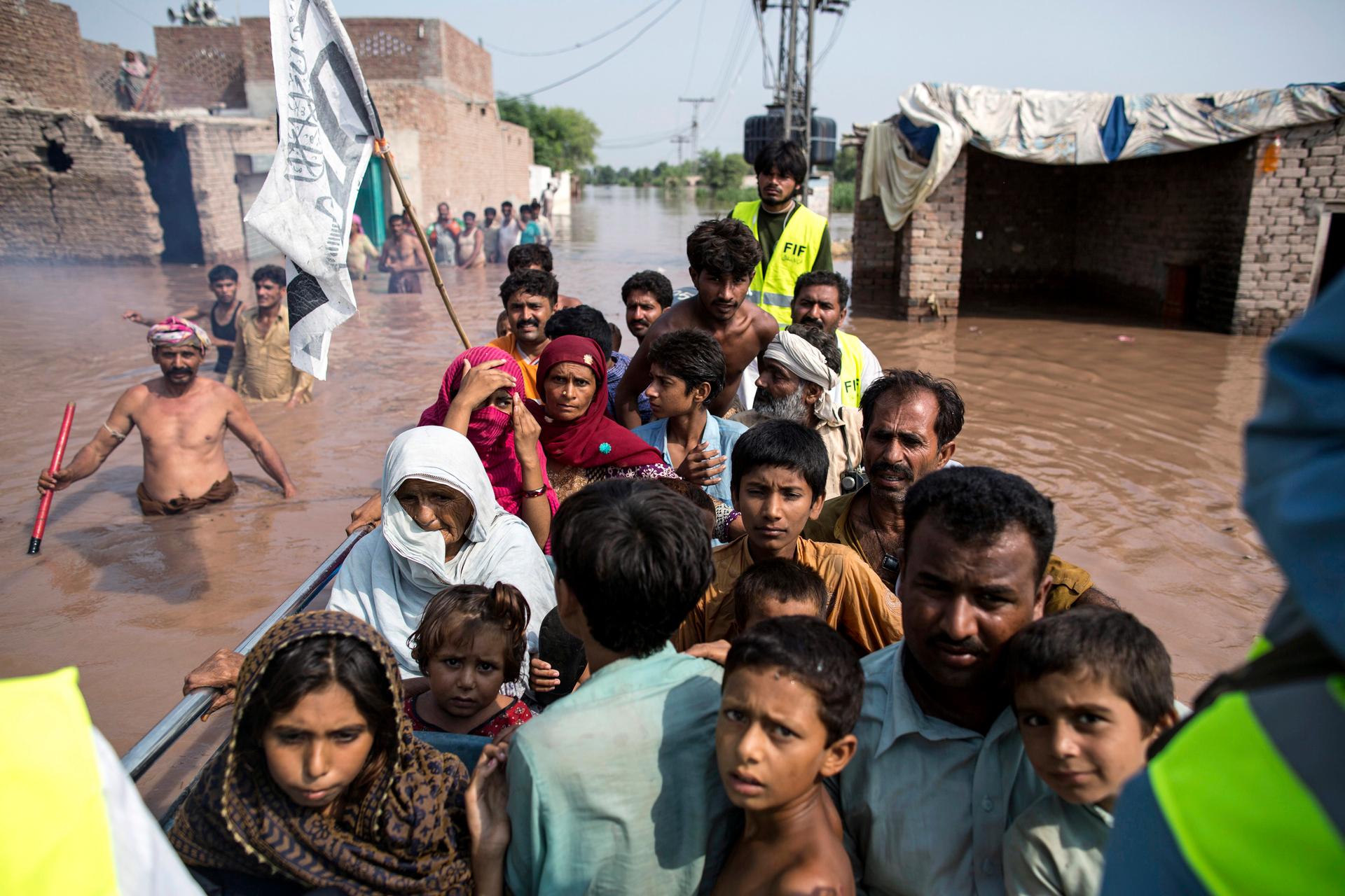 Punjabi flood victims are evacuated by boat from their flooded house following heavy rain in Jhang, Pakistan, on September 10, 2014. 