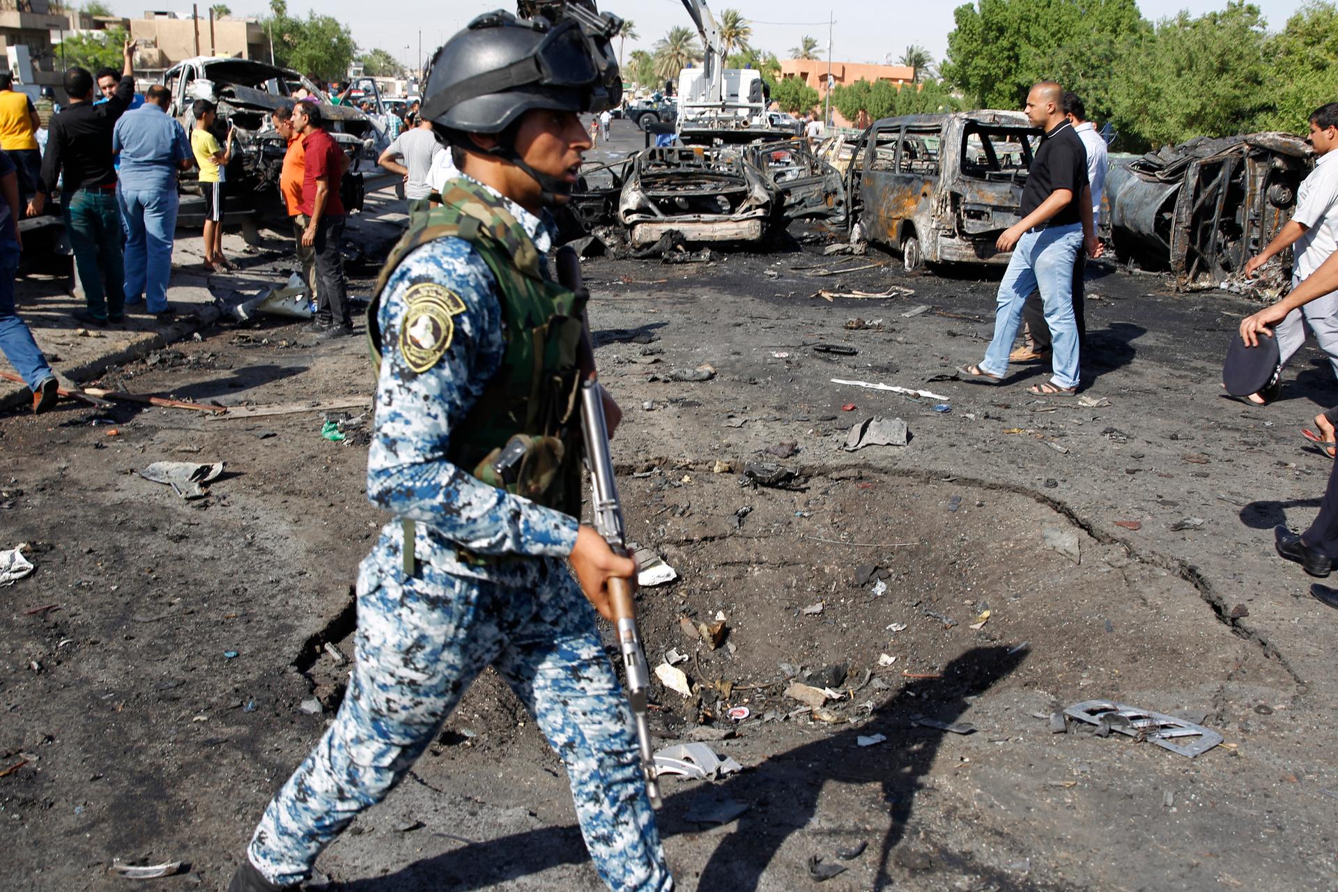 Iraqi security forces inspect the site of three explosions in the New Baghdad neighborhood on September 10, 2014. 