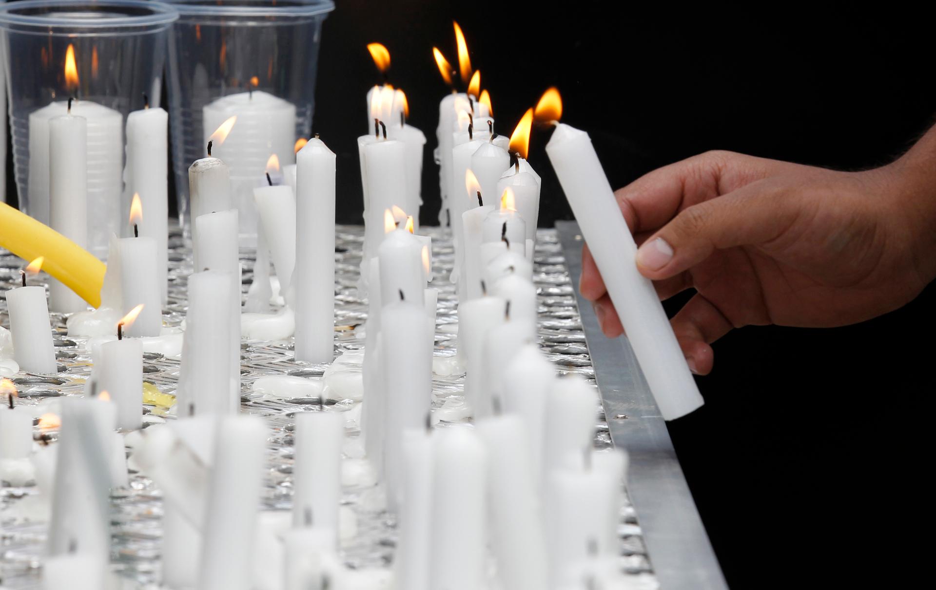 A relative of a victim lights a candle during the first anniversary memorial service of the Westgate shopping mall terrorist attack in Kenya's capital Nairobi on September 21, 2014.