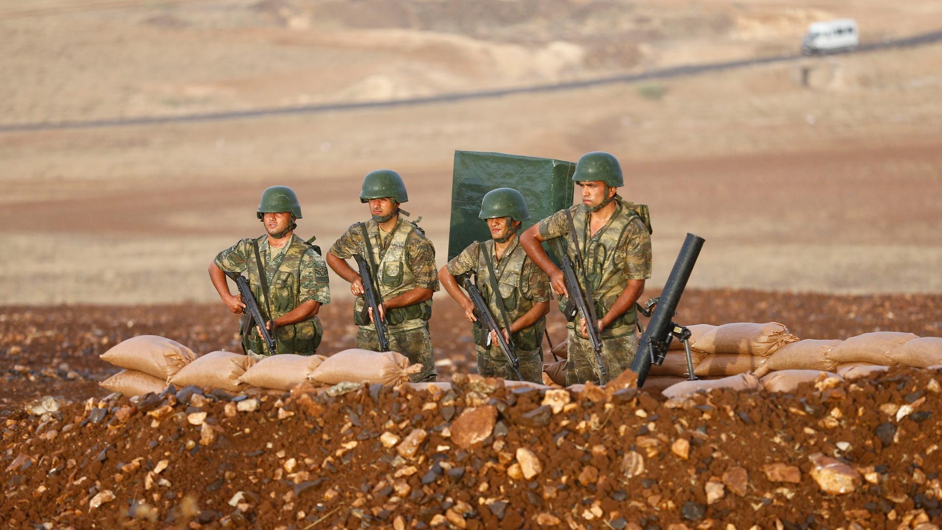 Turkish soldiers stand at a position on the Turkish-Syrian border near the southeastern town of Suruc on September 24, 2014.