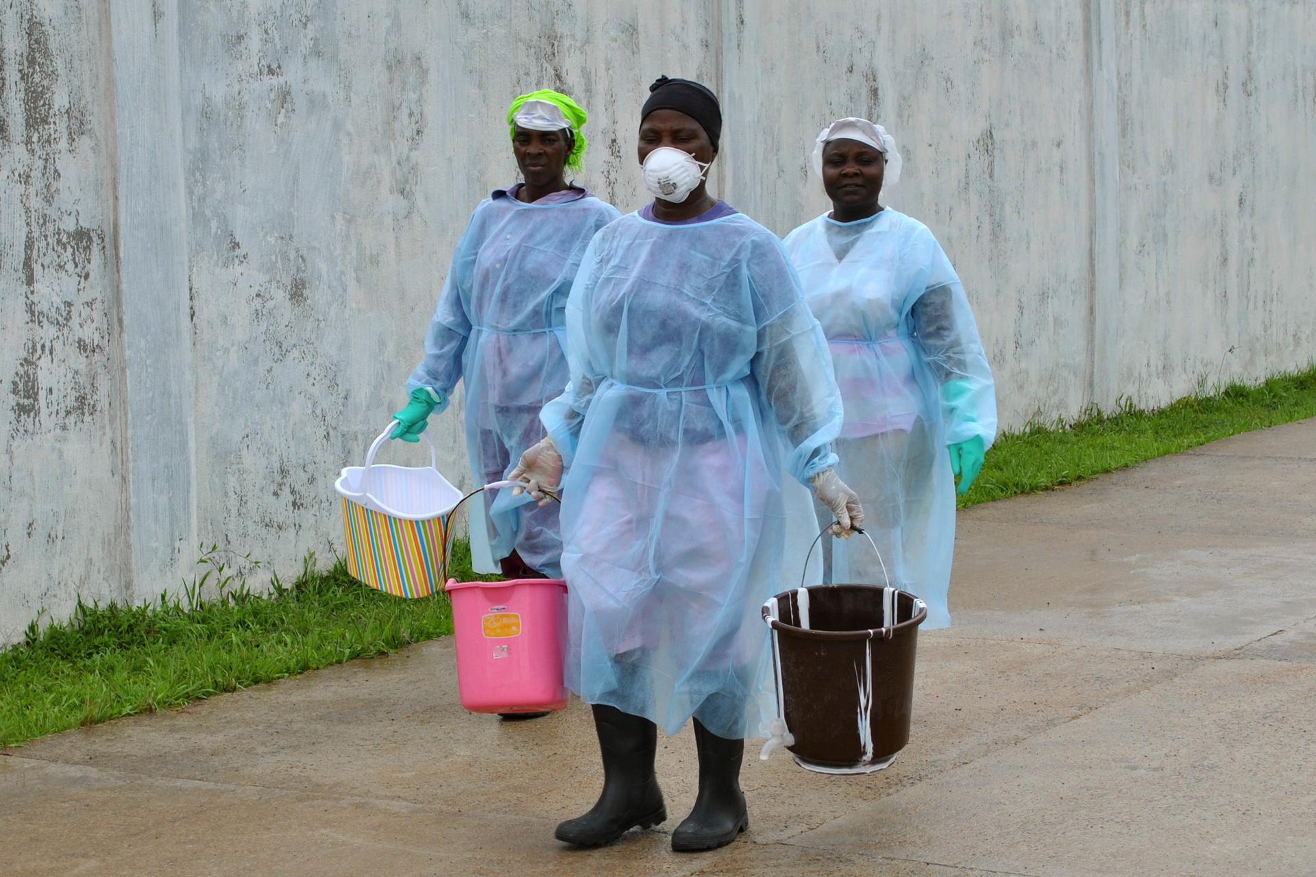 Health workers carry buckets of disinfectant at the newly-constructed Island Clinic and Ebola treatment center in Monrovia, Liberia, September 25, 2014.