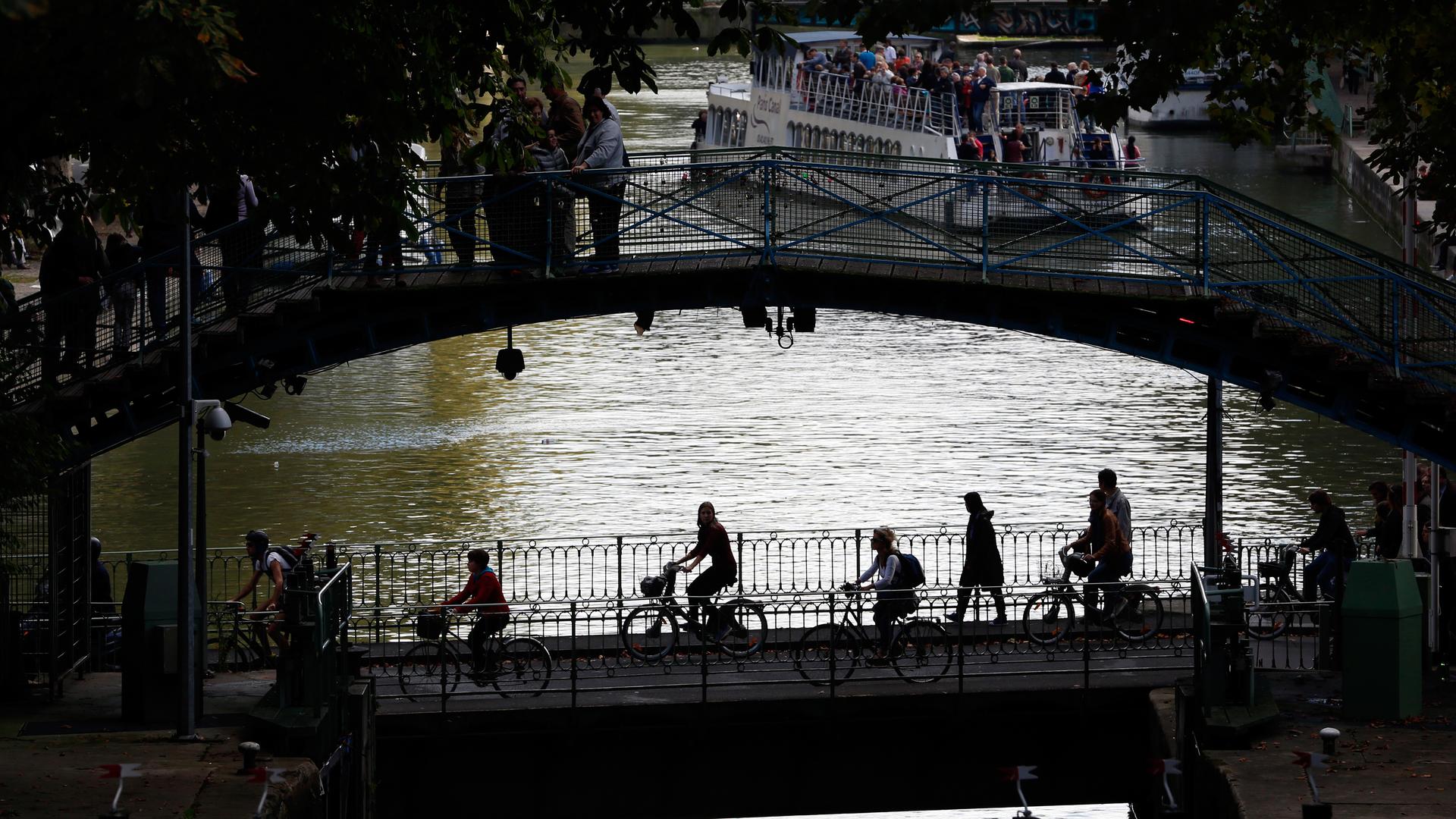 People ride bicycles across the Canal Saint-Martin in Paris, the city’s main canal. 