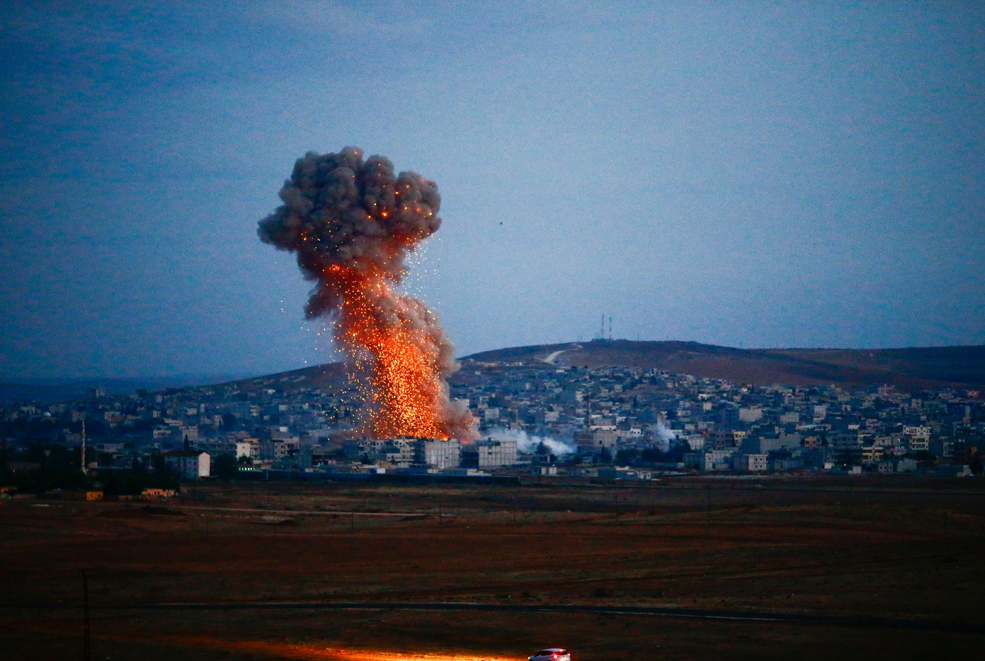 Smoke rises over Syrian town of Kobani after an airstrike, as seen from the Mursitpinar border crossing on the Turkish-Syrian border in the southeastern town of Suruc in Sanliurfa province, October 18, 2014. 