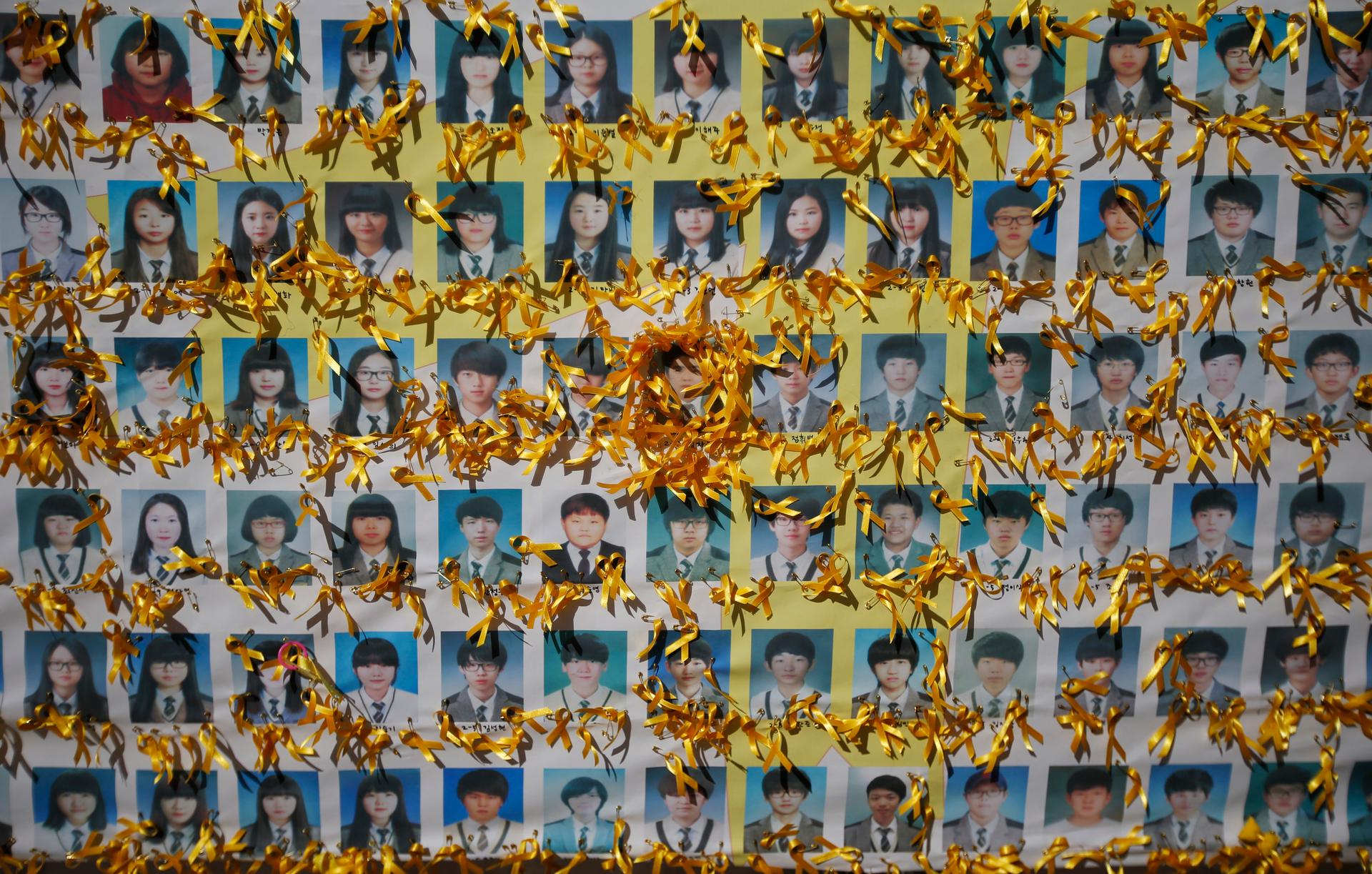 Yellow ribbons adorn portraits of South Korean students who died in the mid-April ferry disaster. South Korean prosecutors on Monday sought the death penalty for Lee Joon-seok, 68, the captain of the ferry that capsized in April, leaving 304 people dead o