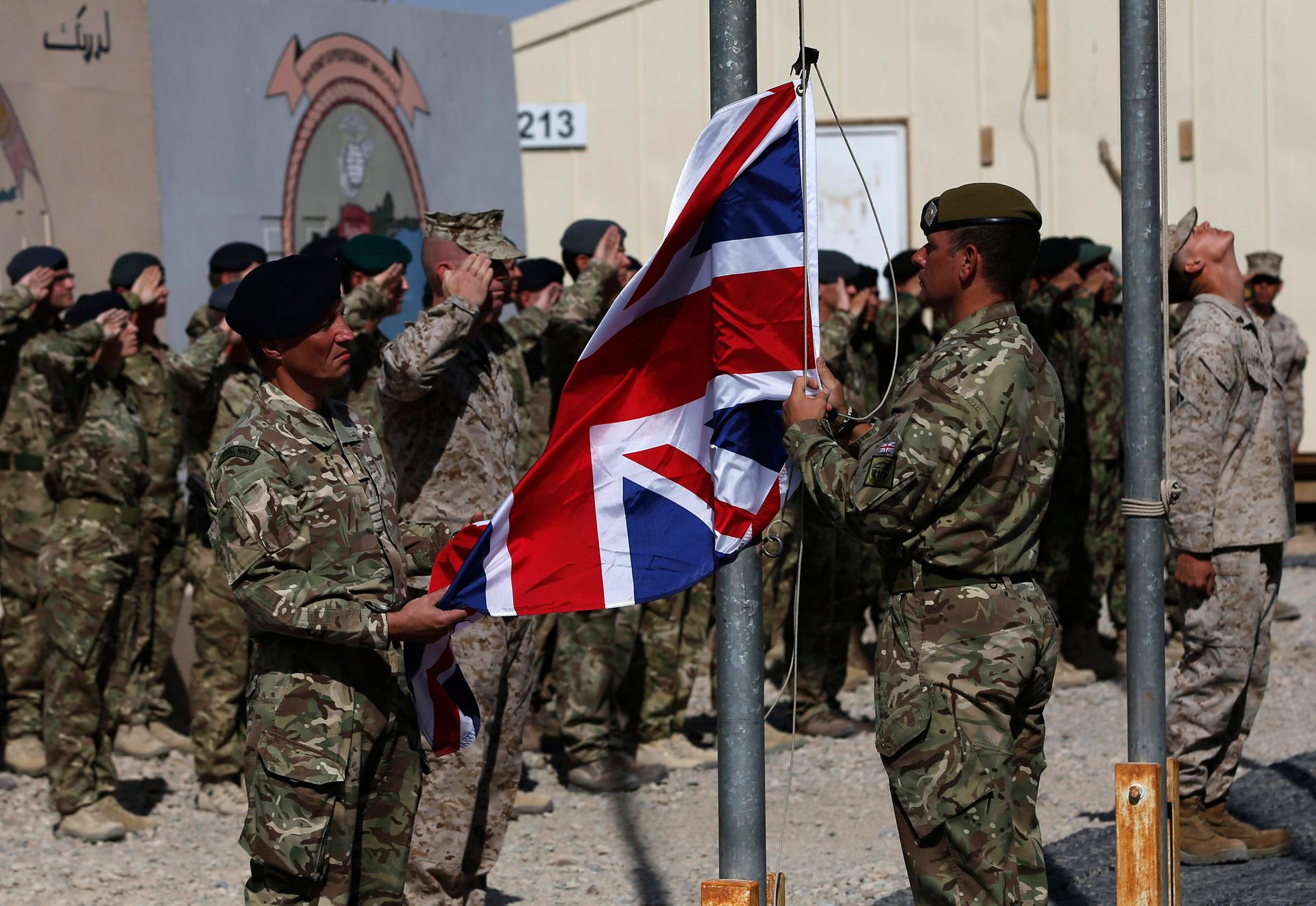 British troops lower the Union Flag during a ceremony marking the end of operations for US Marines and British combat troops in Helmand on October 26, 2014.