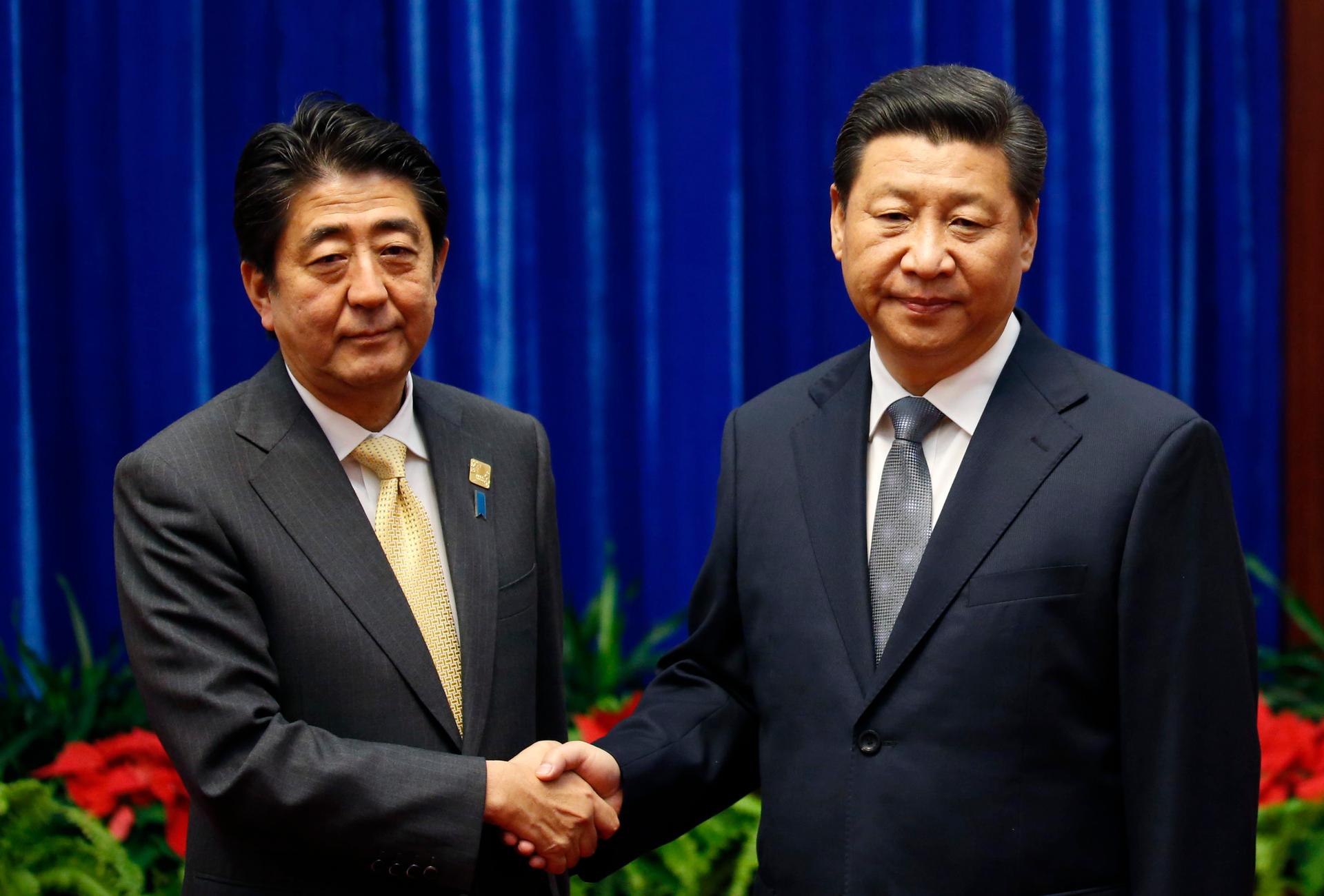 President Xi Jinping of China (on right) shakes hands with Japan's Prime Minister Shinzo Abe during their meeting on the sidelines of the Asia Pacific Economic Cooperation meetings in Beijing on Novemeber 10, 2014.