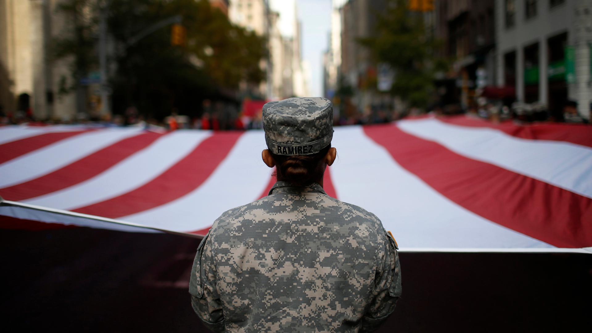 U.S. Army soldiers carry a large U.S. flag as they march in the Veterans Day parade on 5th Avenue in New York November 11, 2014.