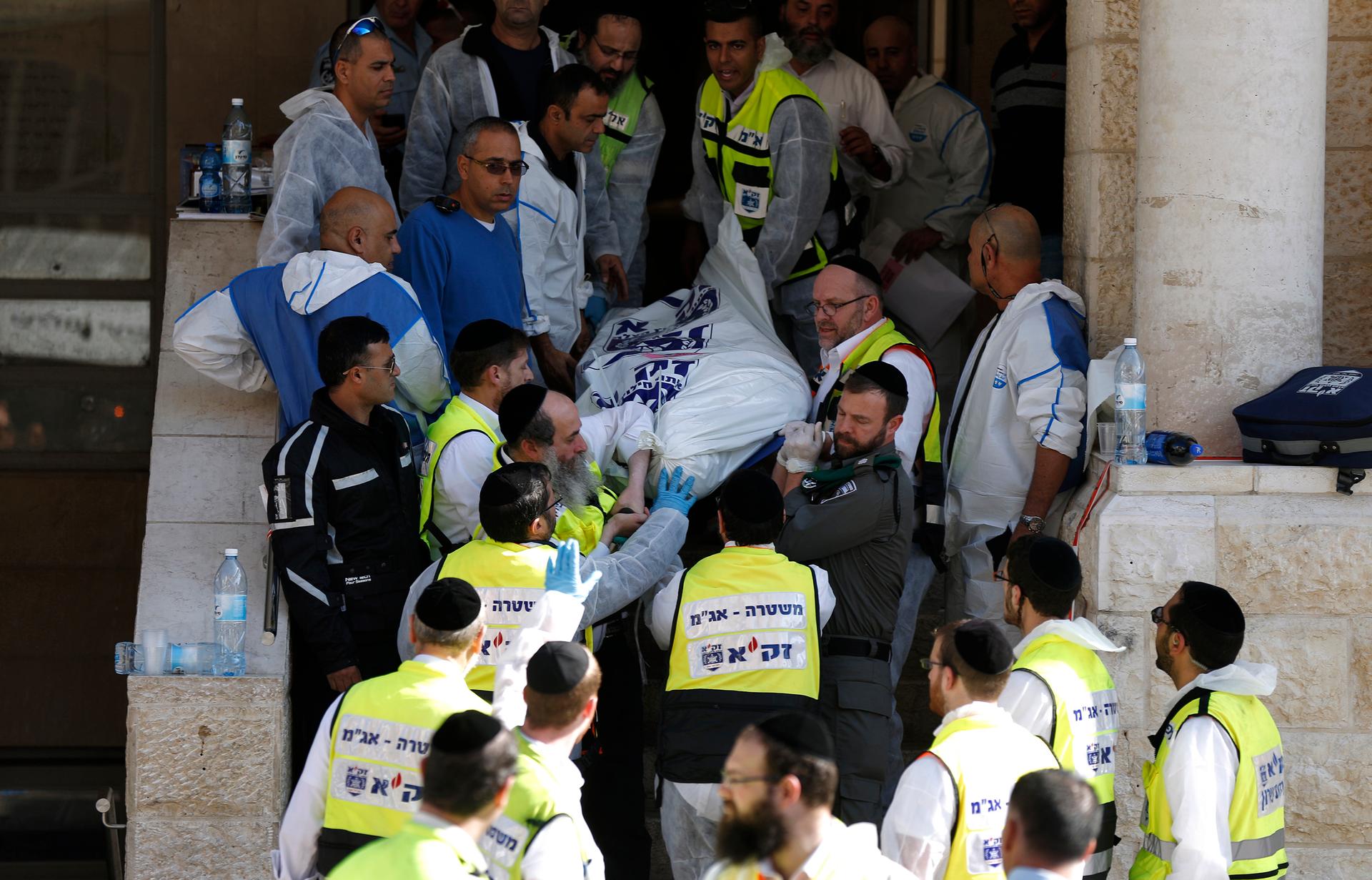 Israeli emergency personnel carry the body of a victim from the scene of an attack at a Jerusalem synagogue on November 18, 2014.