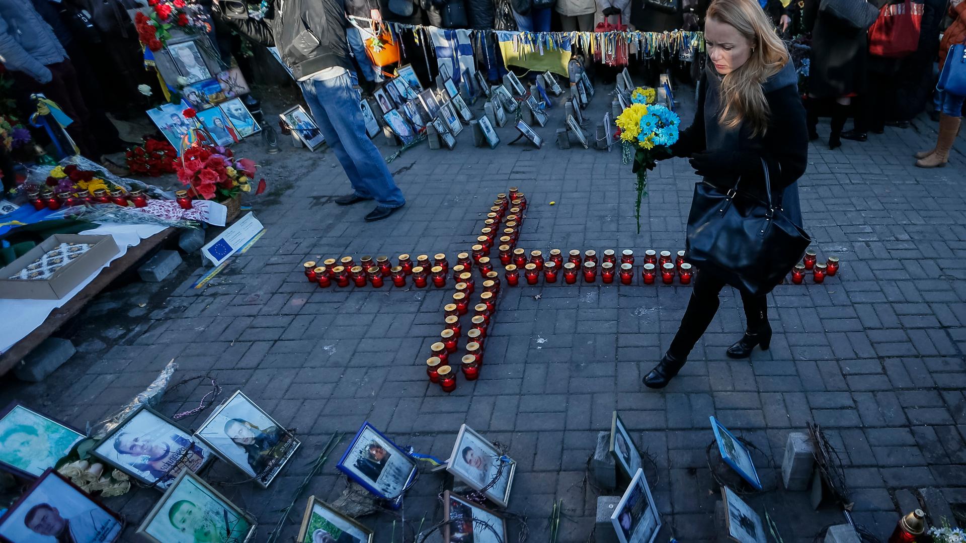 A woman walks near a memorial to those who died protesting against President Yanukovych, during a commemoration ceremony for them in Kiev Friday, as Ukrainians marked the first anniversary of protests which led to the revolution. 