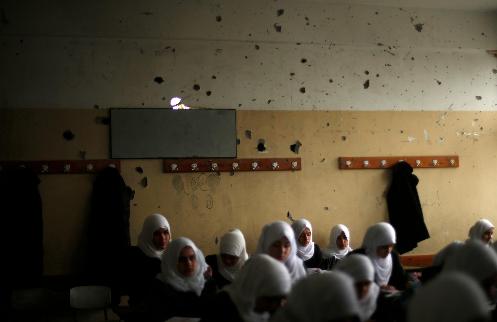 Palestinian school girls attend a class at their school that witnesses said was damaged by Israeli shelling during the most recent conflict between Israel and Hamas.