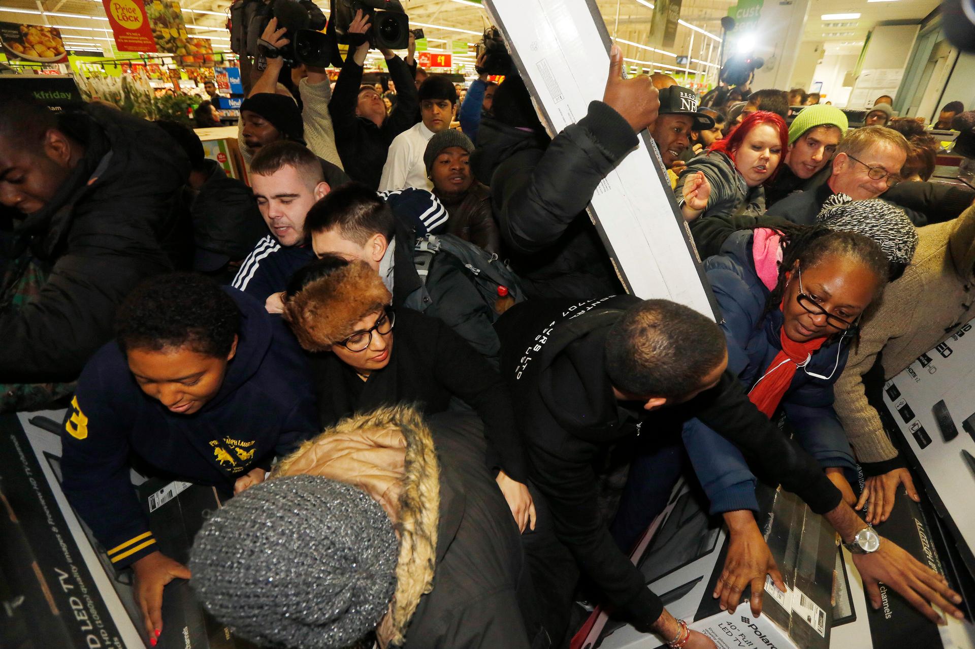 Shoppers compete to purchase retail items on "Black Friday" at an Asda superstore in Wembley, north London November 28, 2014. 