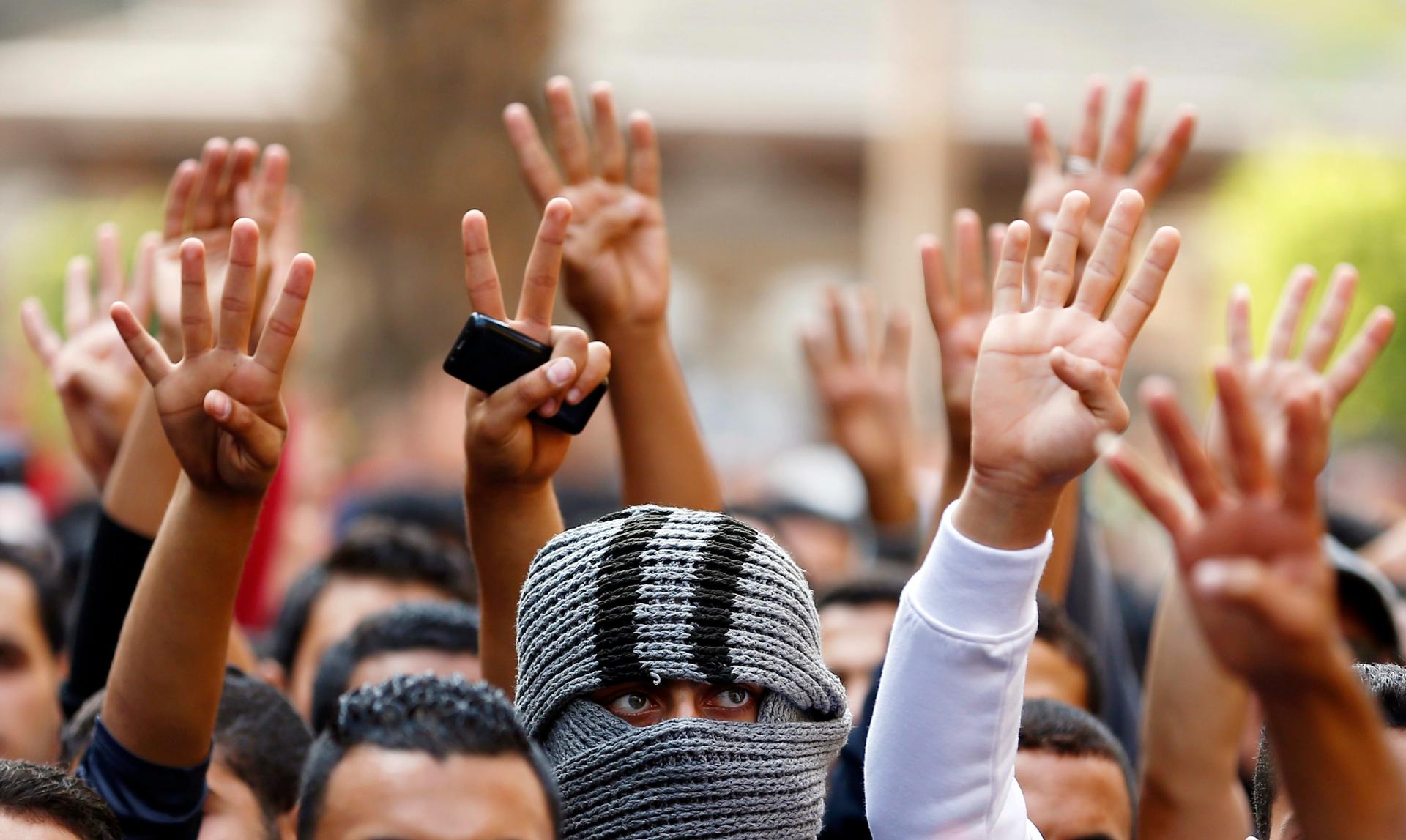 Cairo University students shout slogans against the government and flash the "V" and "Rabaa" signs, protesting the release of former Egyptian President Hosni Mubarak's. Protests erupted at universities across Egypt on November 30, 2014, in response to the