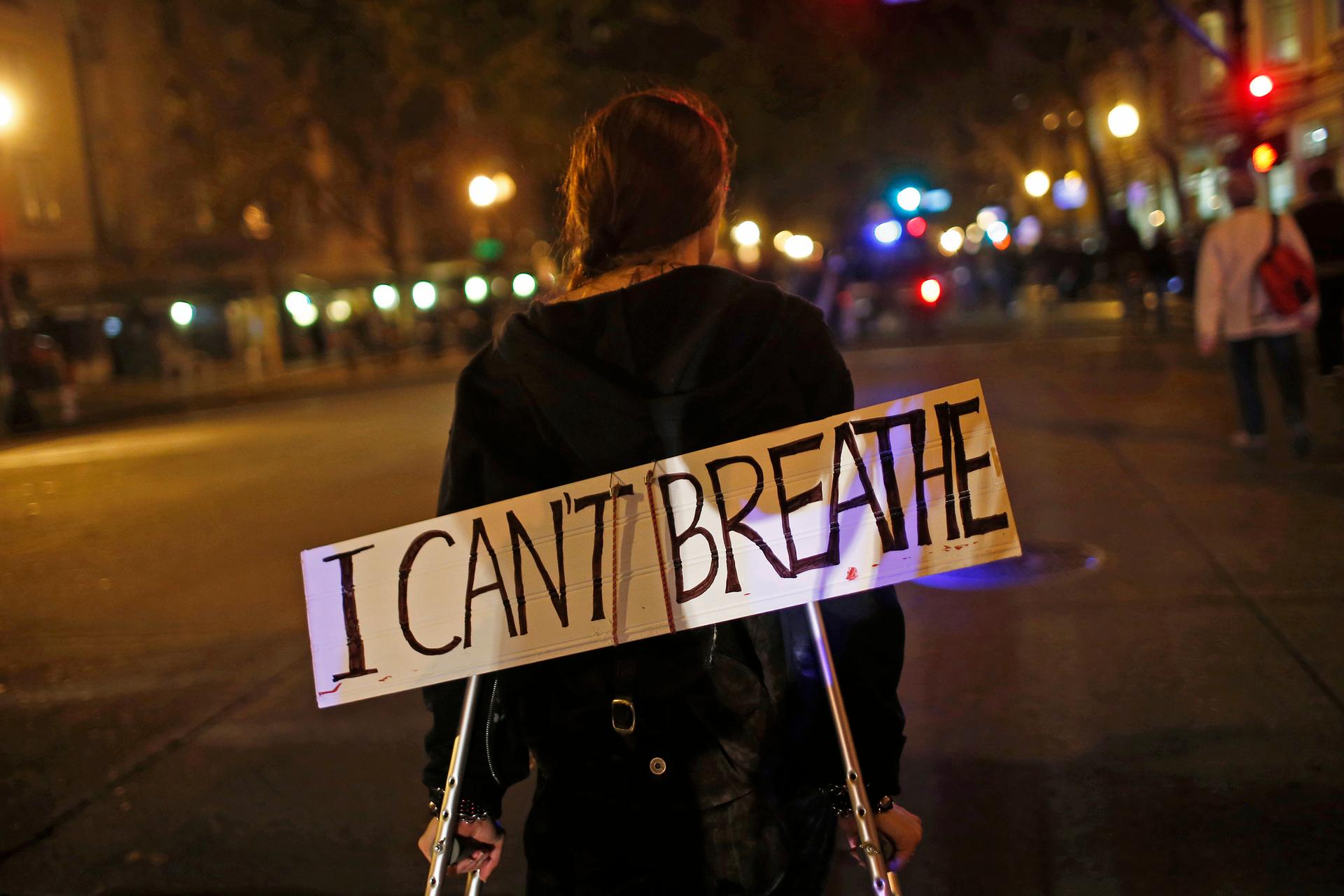 A protester in Oakland, California, on  December 3, 2014, wears a sign during a demonstration against the decision by a New York City grand jury not to indict a police officer in the death of Eric Garner.