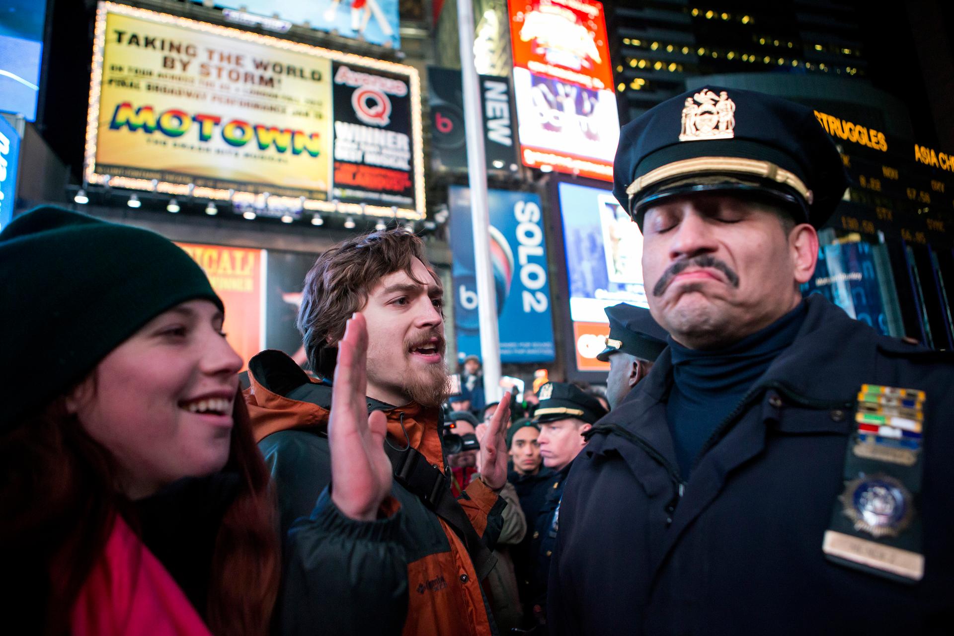 A New York City police officer reacts next to people protesting against the death of Eric Garner during an arrest in July.