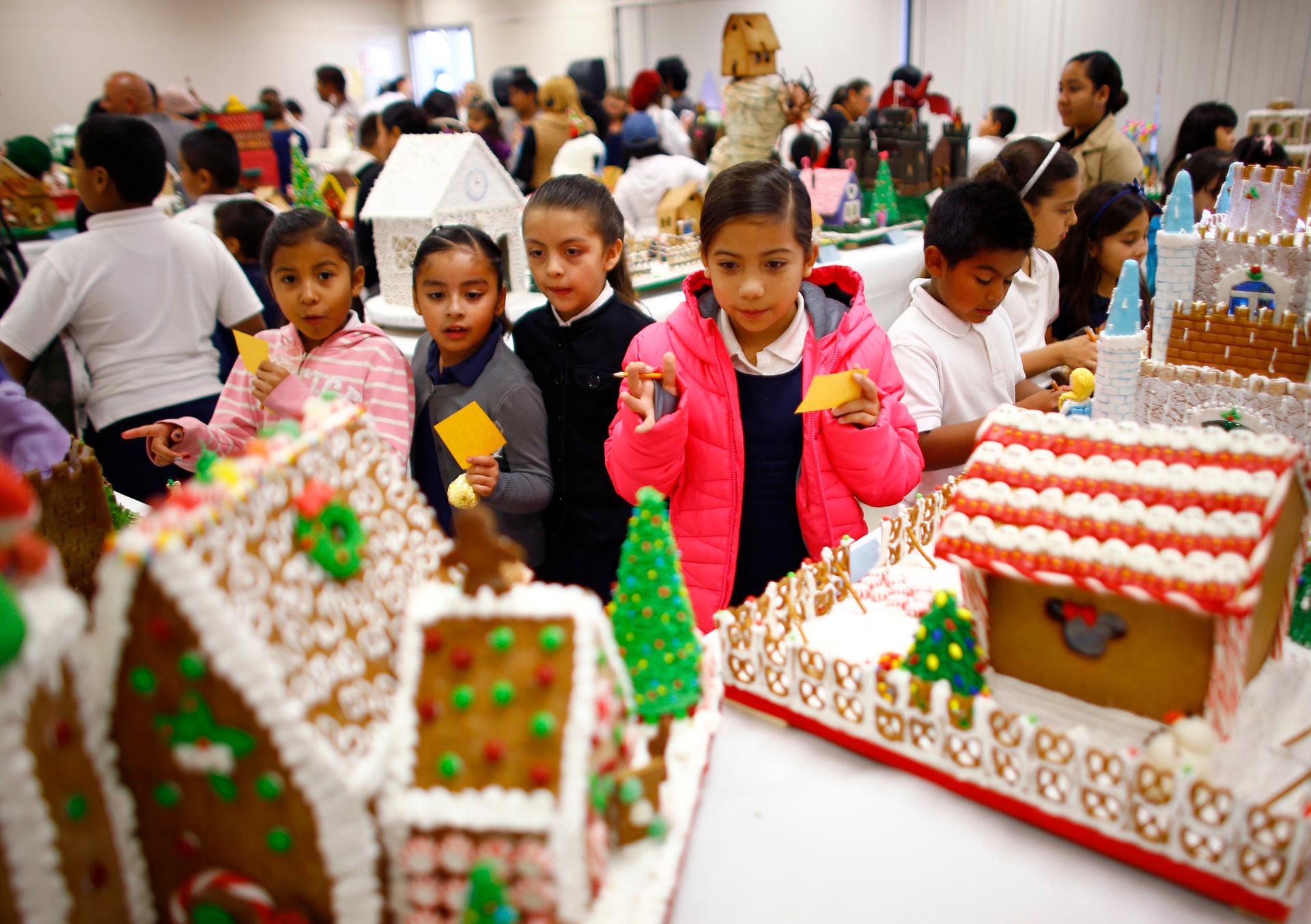 Local elementary school students vote for fairy tale and movie-themed gingerbread houses created by pastry students from the San Ysidro Adult School Culinary Arts program in San Ysidro, California on December 9, 2014.