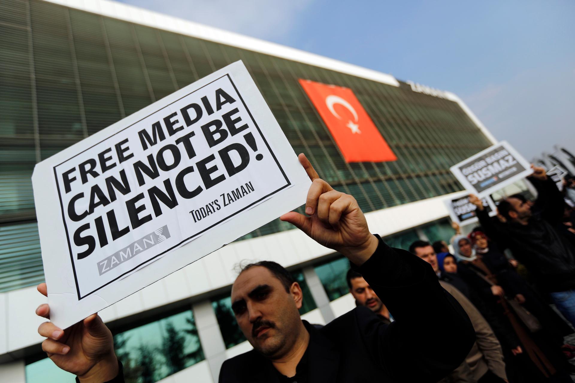 Journalists of Turkey's Zaman daily newspaper in Istanbul protest a police raid of the media outlet. 24 people including top executives and ex-police officers were round up in what Turkish president Tayyip Erdogan calls a terrorist network conspiring to t