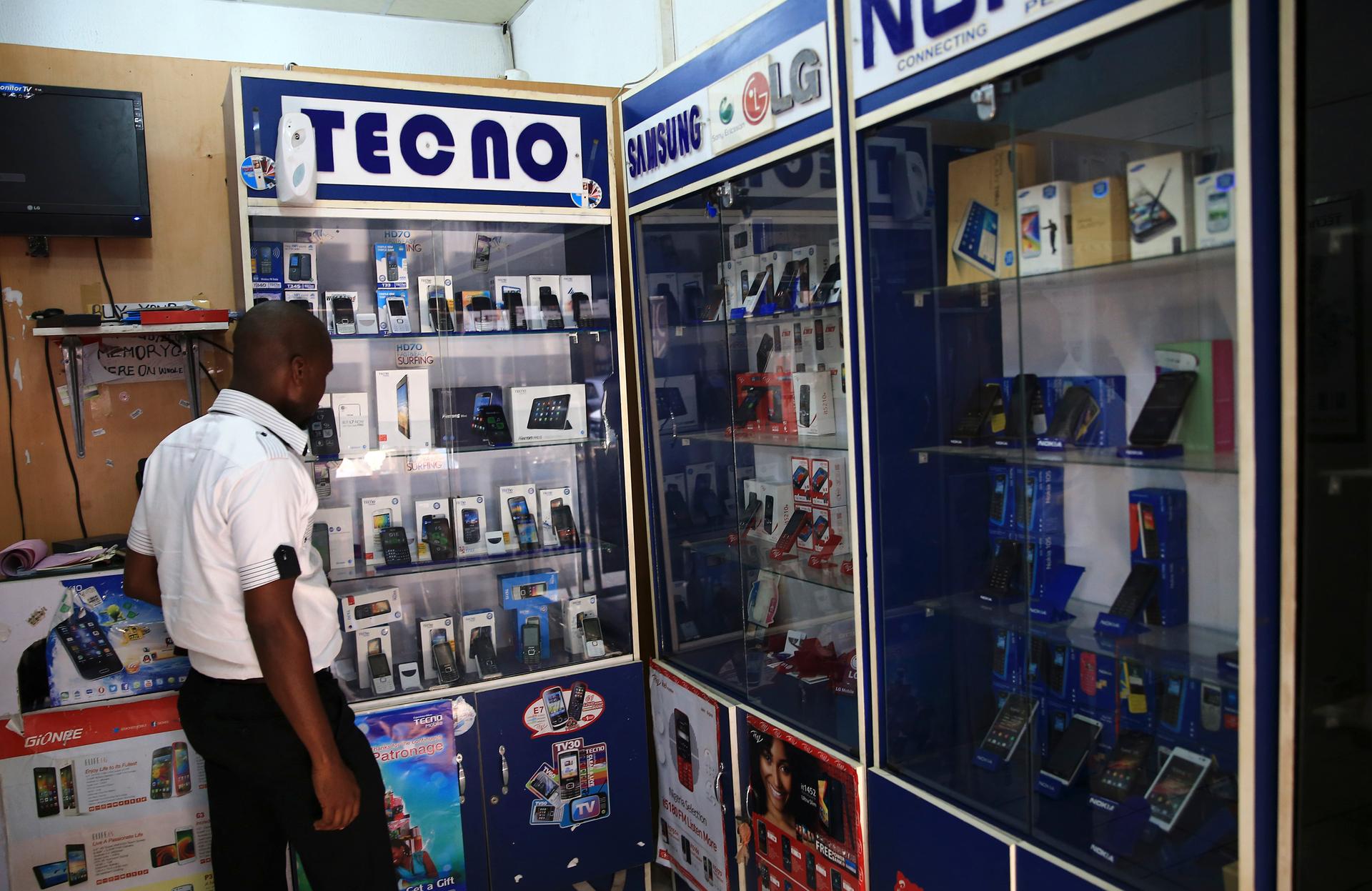A man looks at smartphones on display at a shop at Wuse II business district in Abuja December 9, 2014.
