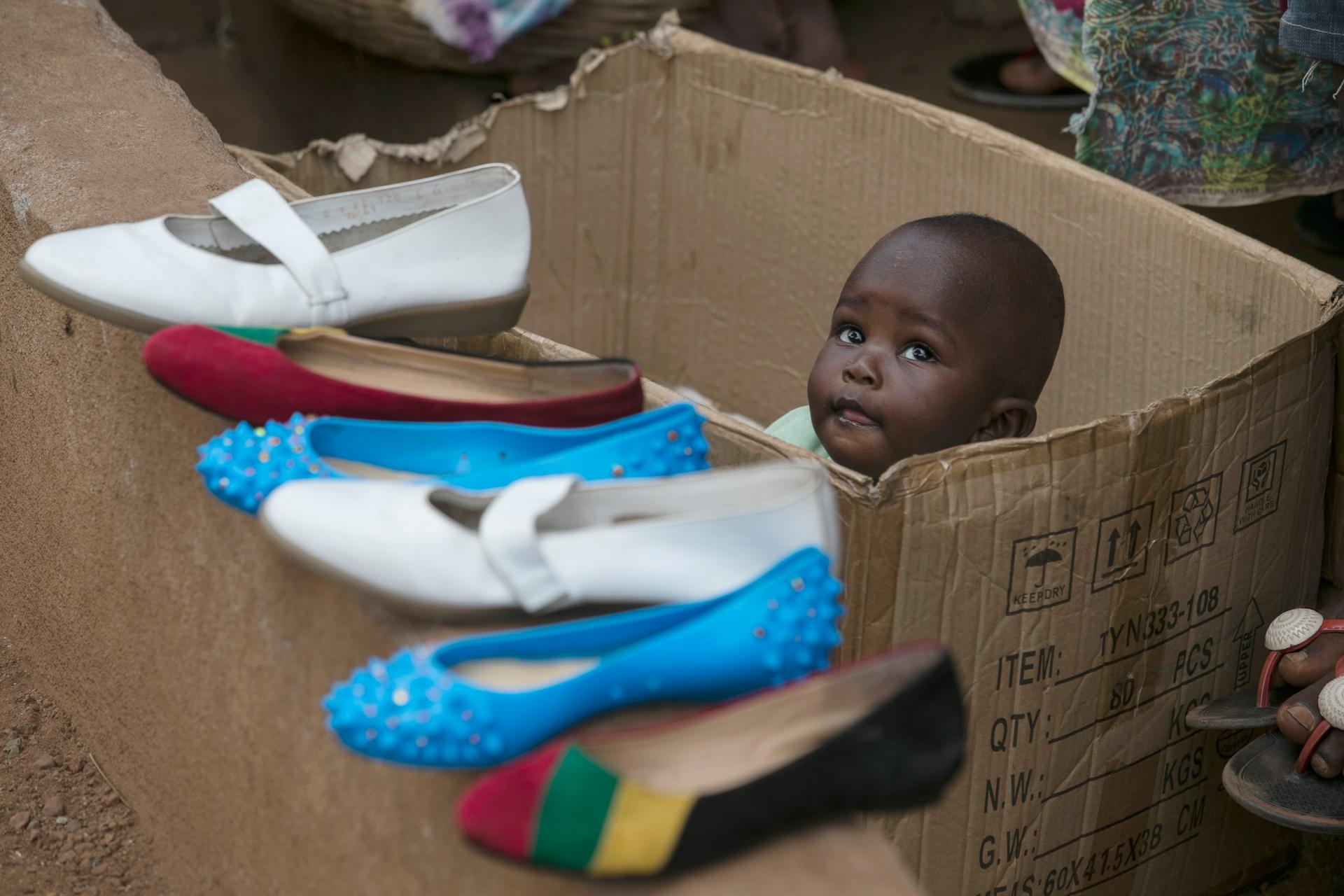 A baby looks out of a box at an outdoor market in Devils Hole, Sierra Leone. A new report suggests Ebola has created 12,000 orphans in the West African country. 