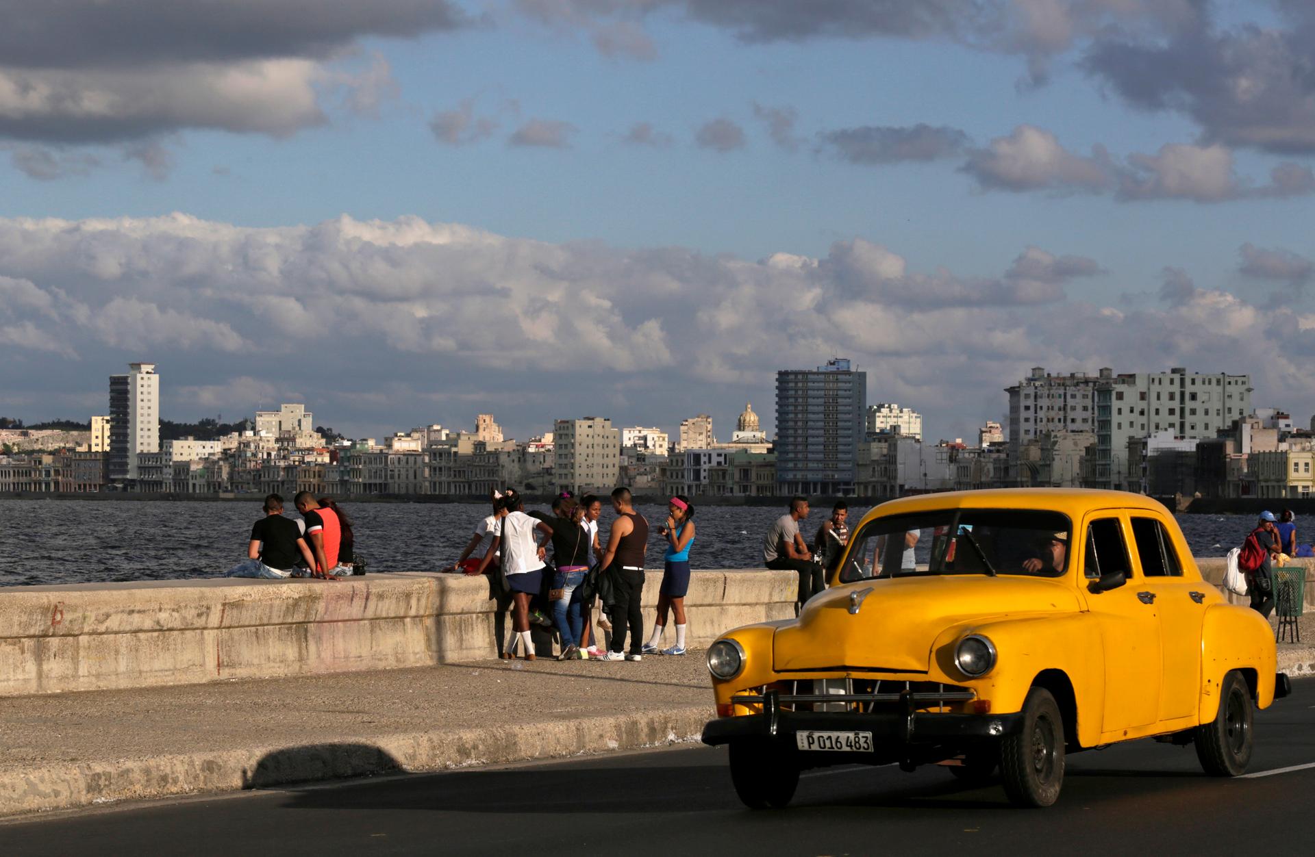 Youth sit on Havana's El Malecon seafront bolulevard December 17, 2014.