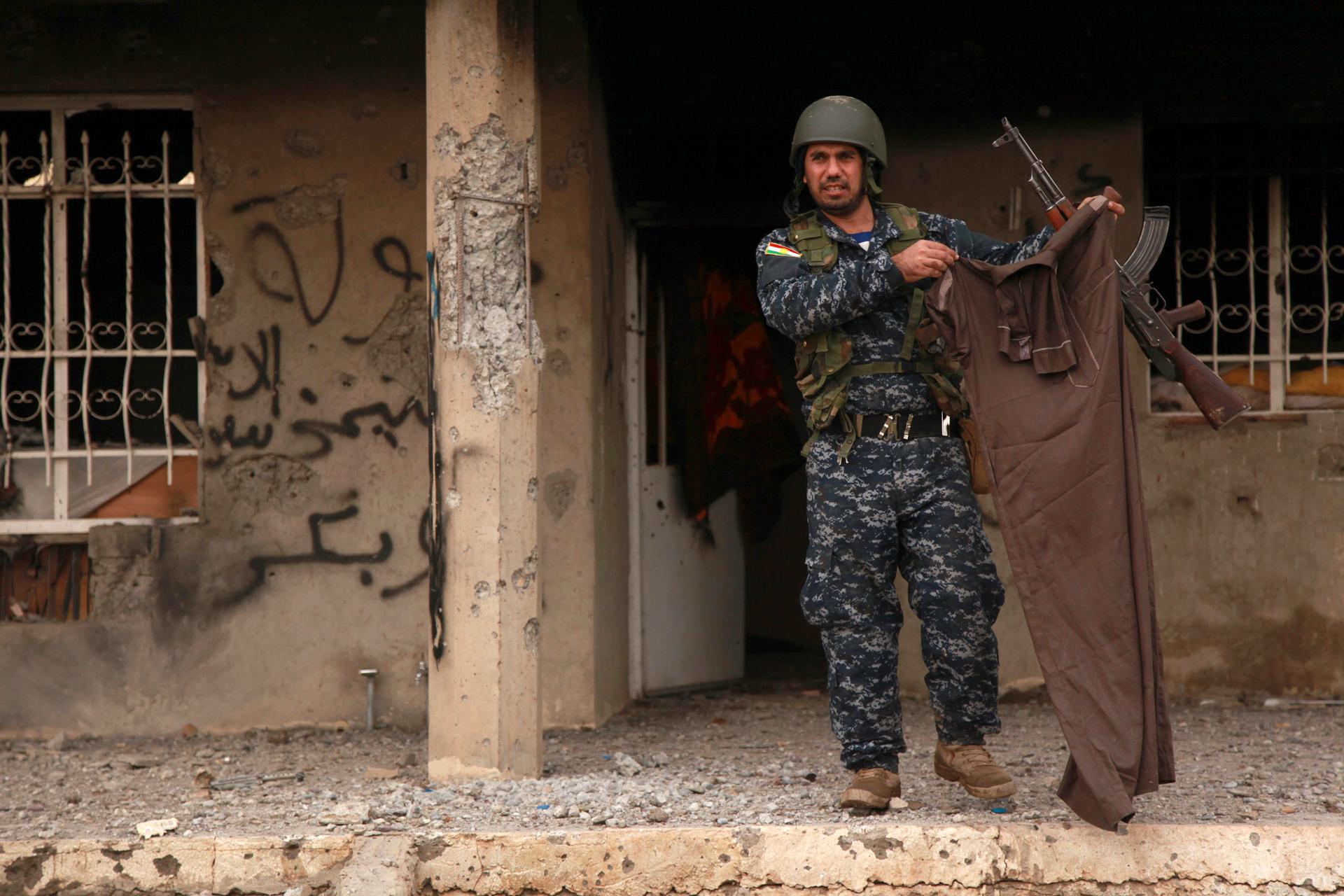 A Kurdish peshmerga fighter holds up a piece of clothing worn by an ISIS fighter on December 18, 2014. Kurdish peshmerga fighters have fought their way to Iraq's Sinjar mountain and freed hundreds of people trapped there by ISIS.