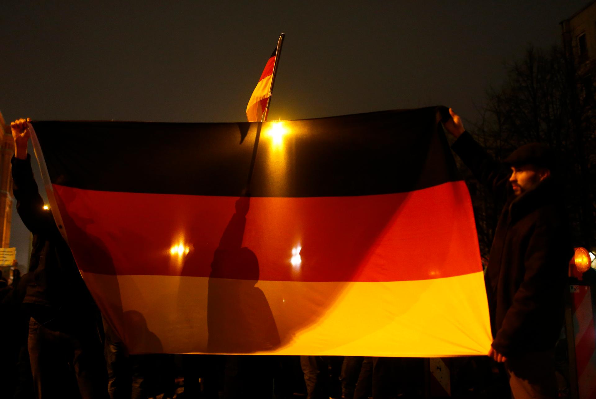 Participants in a grassroots anti-Muslim movement hold German flags during a demonstration in Berlin. The rise of the group, Patriotic Europeans Against the Islamisation of the West, has shaken Germany's political establishment.