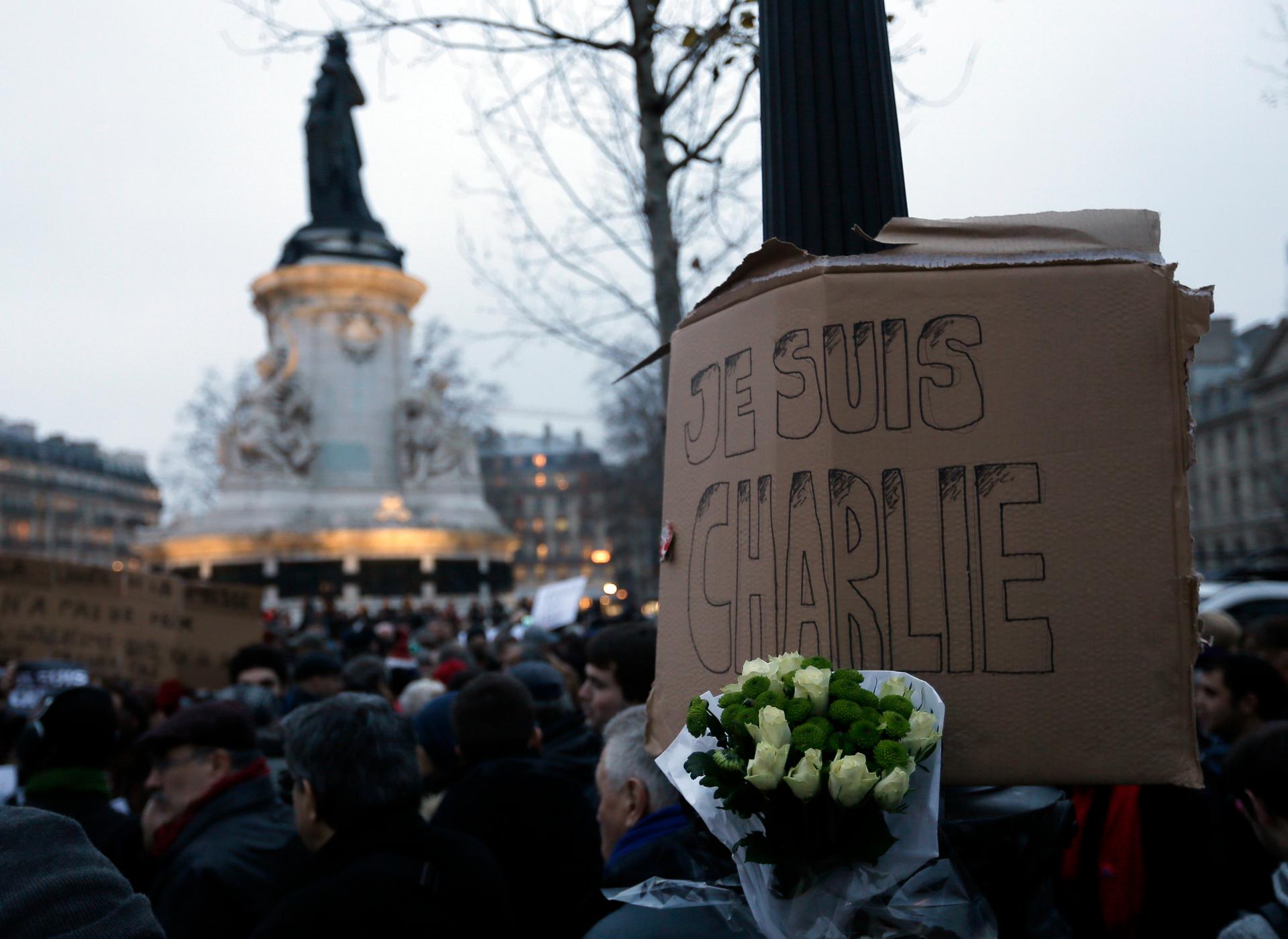 A bouquet of roses is seen near a placard reading "I am Charlie," displayed to pay tribute during a gathering at the Place de la Republique in Paris on January 7, 2015, following a shooting by gunmen at the offices of weekly satirical magazine Charlie Heb