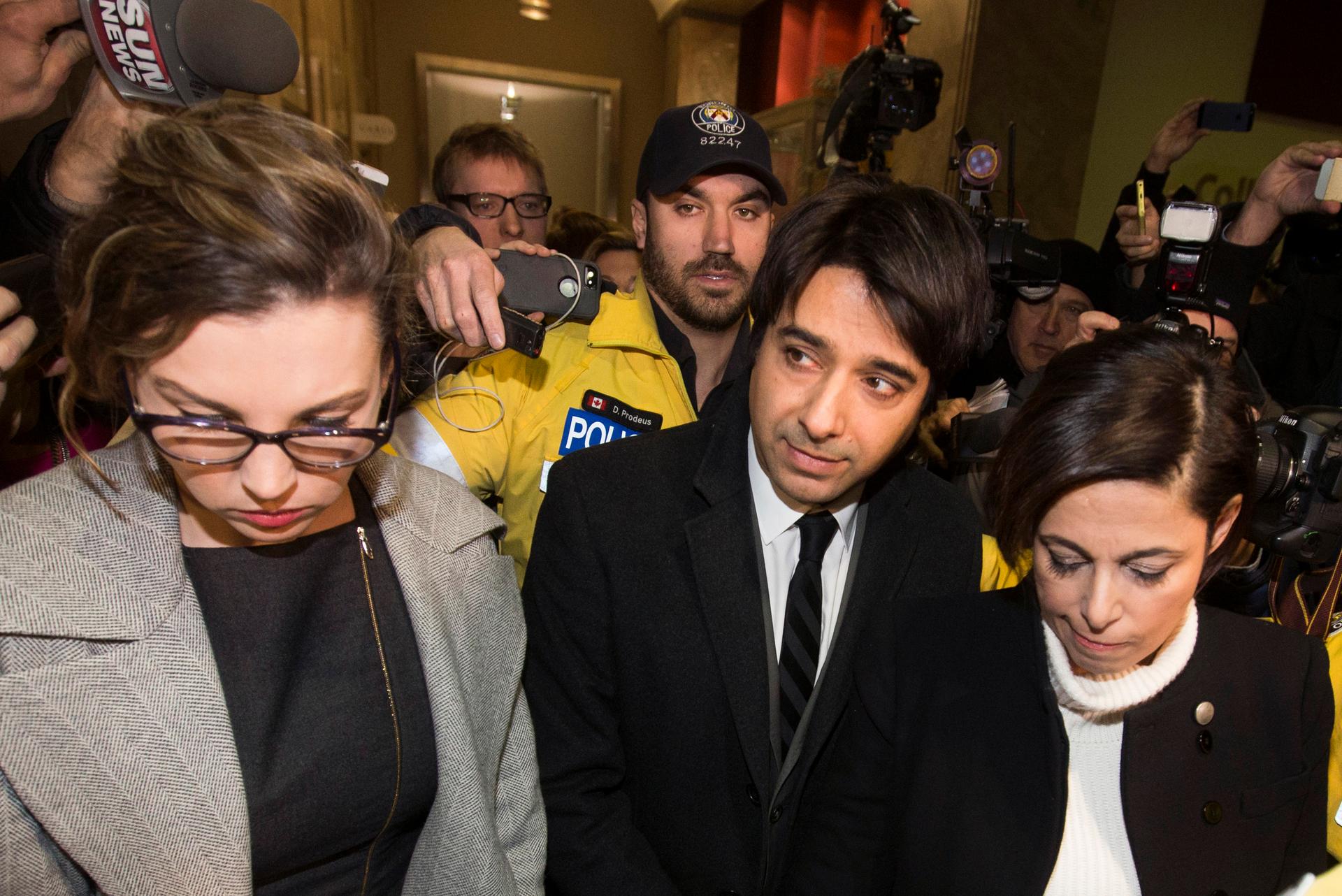A Canadian radio talk show program is relaunching following the firing of former host Hian Ghomeshi, center, who is facing charges of harassment. 