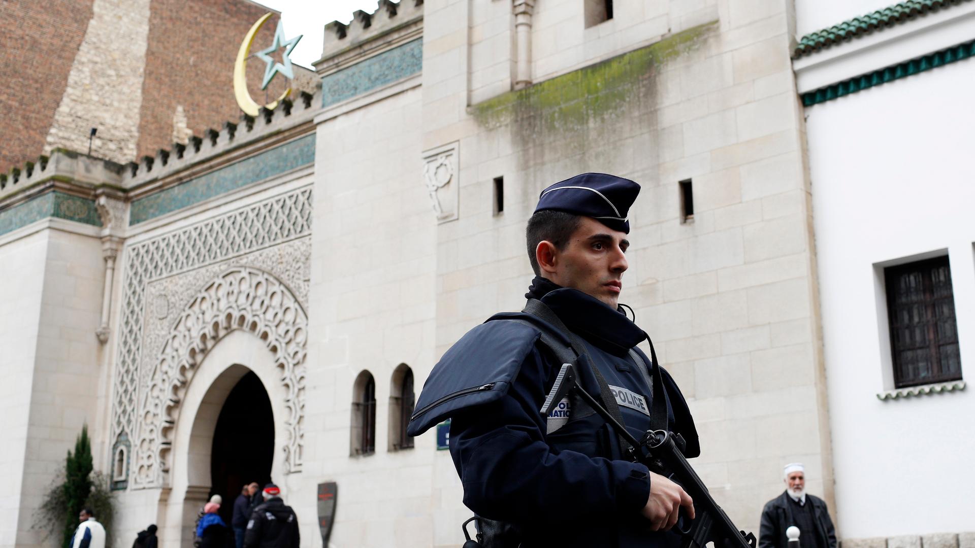 A French policeman stands in front of the entrance of Paris Mosque as French Muslims gather for Friday prayers in Paris January 9, 2015, following Wednesday's deadly attack at the Paris offices of weekly satirical newspaper Charlie Hebdo by two masked gun