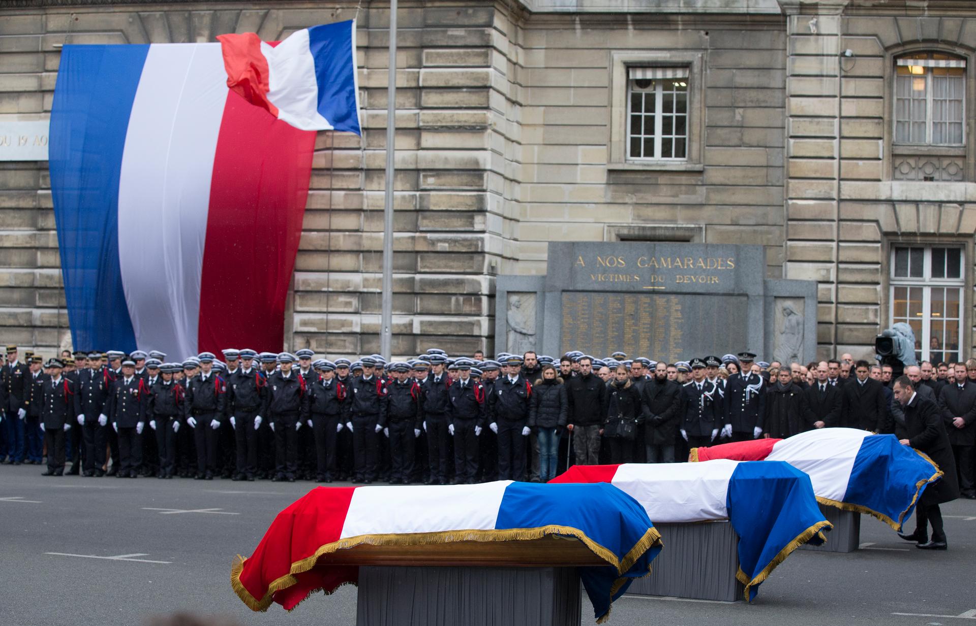 French police officers pay respects at a national tribute in Paris to the three officers who fell during last week's attacks by Islamic militants.  