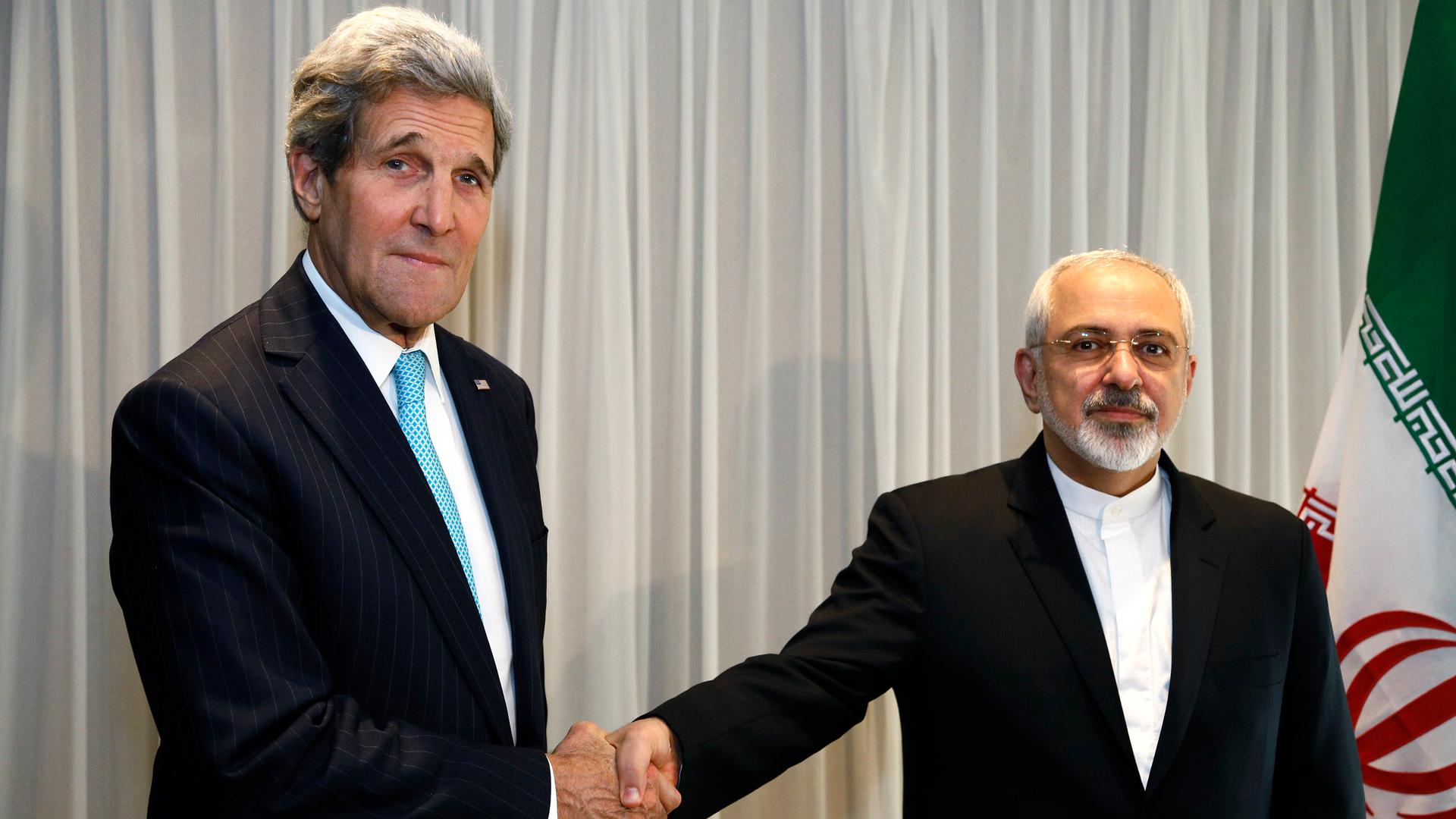 US Secretary of State John Kerry shakes hands with Iranian Foreign Minister Mohammad Javad Zarif before a meeting in Geneva on January 14, 2015.