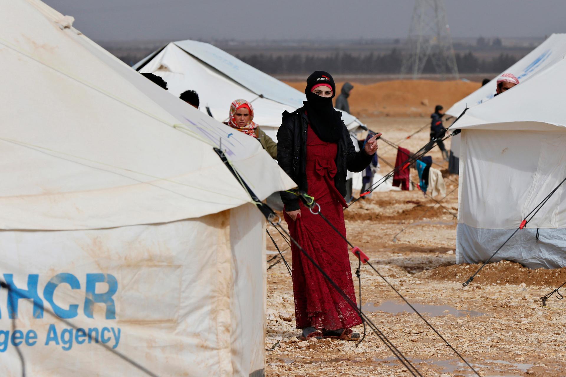 A Syrian refugee woman stands near her tent at the Al Zaatari refugee camp in the Jordanian city of Mafraq, near the border with Syria, January 15, 2015.