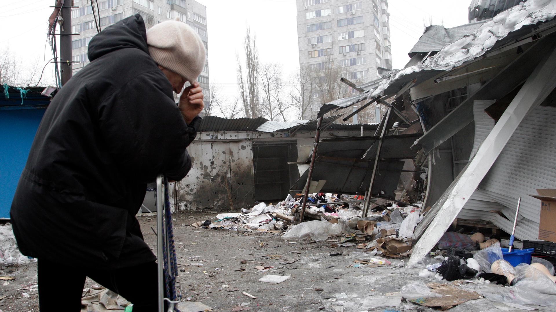 A woman reacts as she stands at a market that, according to locals, was recently damaged by shelling in Donetsk. 