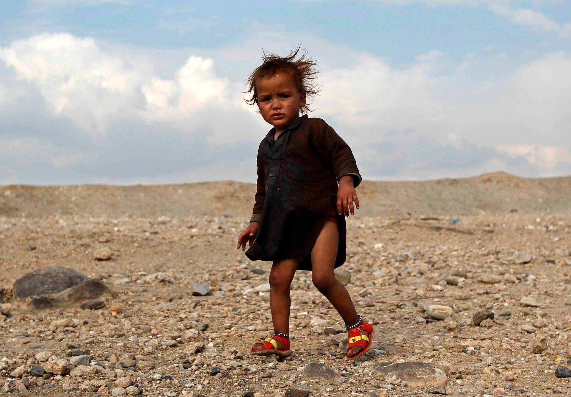 An internally displaced Afghan child stands outside a shelter outside Jalalabad city.