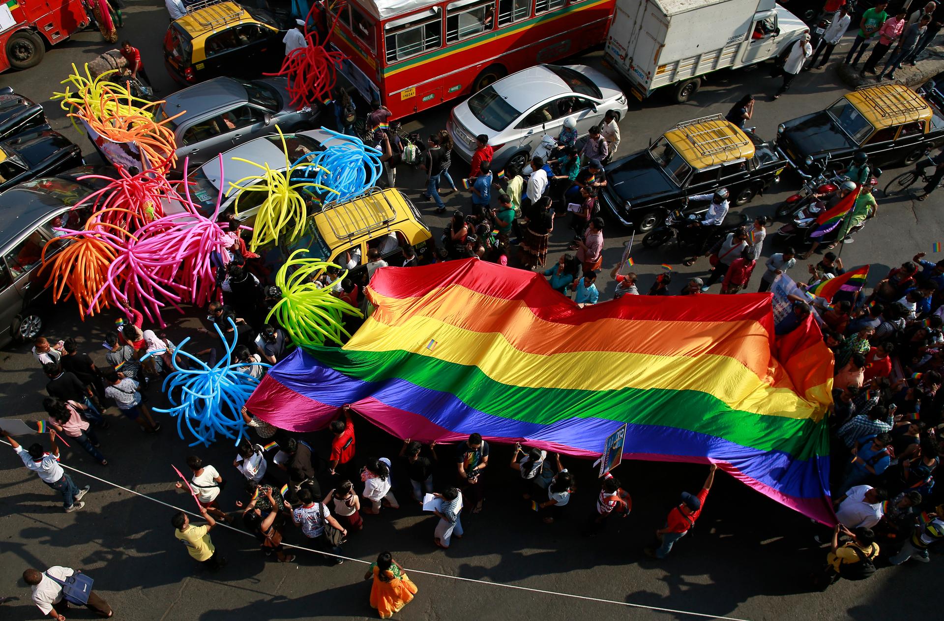 Participants holding a rainbow flag pass through a junction during a gay pride parade, which is promoting gay, lesbian, bisexual and transgender rights, in Mumbai, January 31, 2015. 