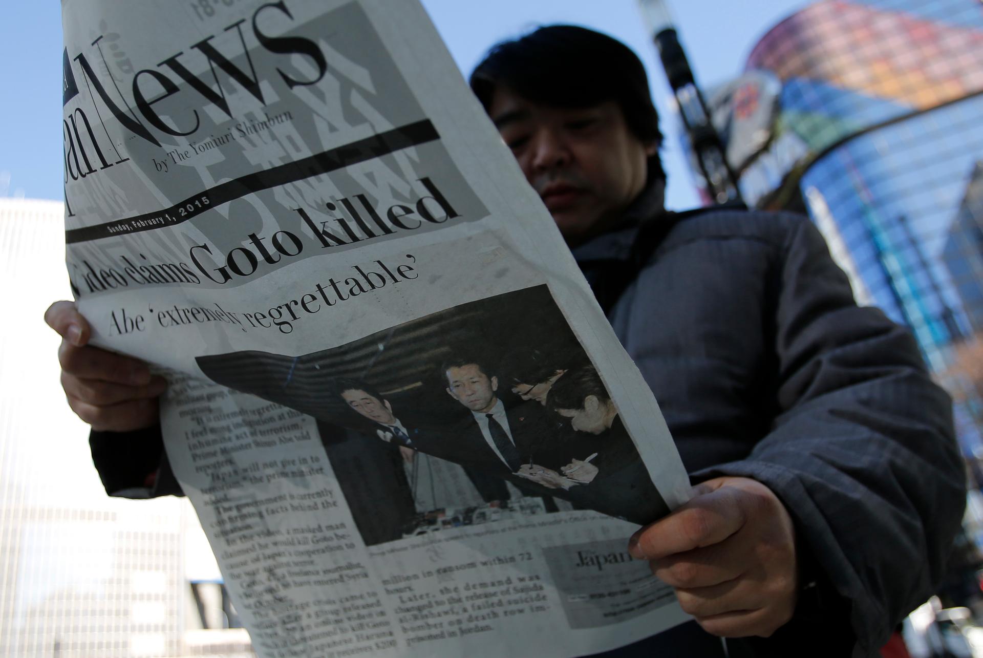 A man in Tokyo's Ginza district reads an extra edition of a newspaper, which reported ISIS' claim to have beheaded Japanese journalist Kenji Goto on February 1, 2015.