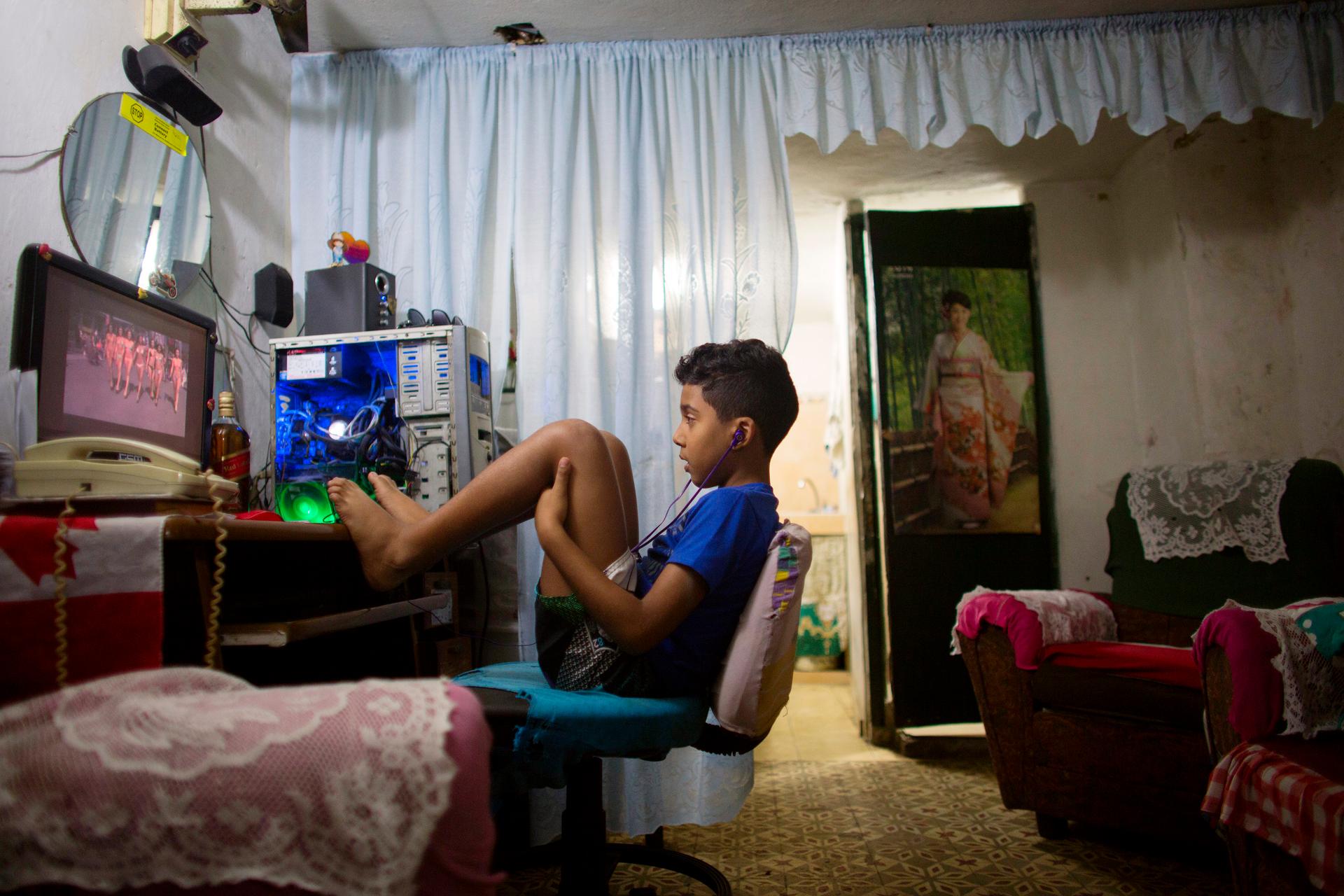Havana resident Kevin Lachaise watches a recorded TV show on a computer screen in the living room of his home.